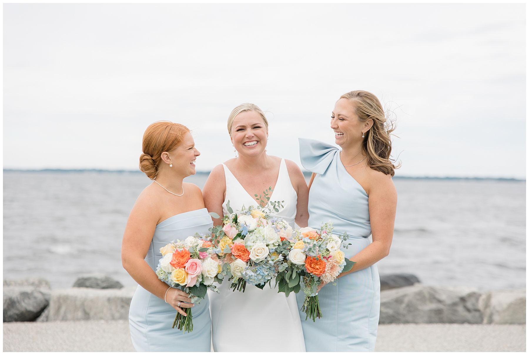 bride with bridesmaids by the water