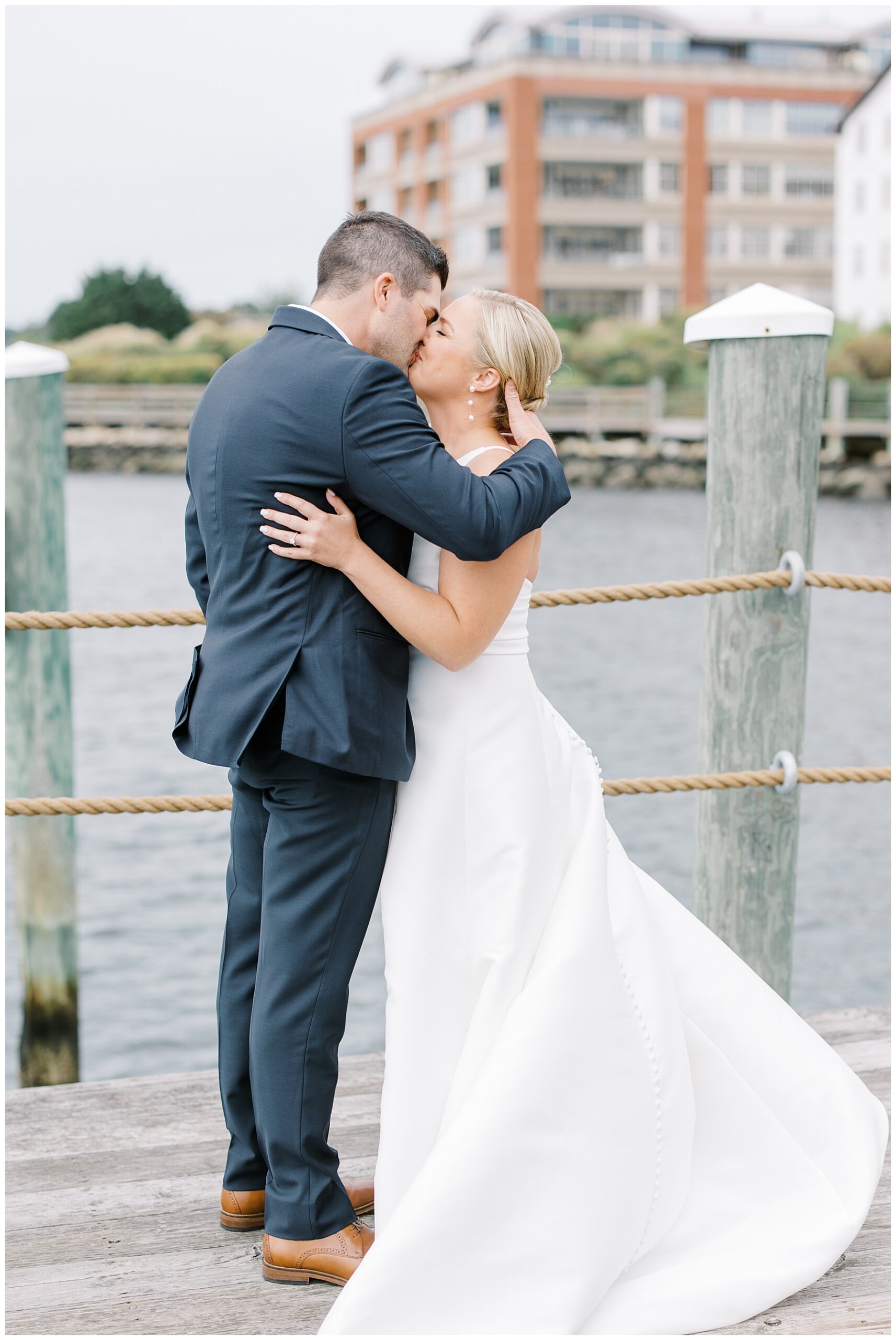bride and groom kiss on the dock