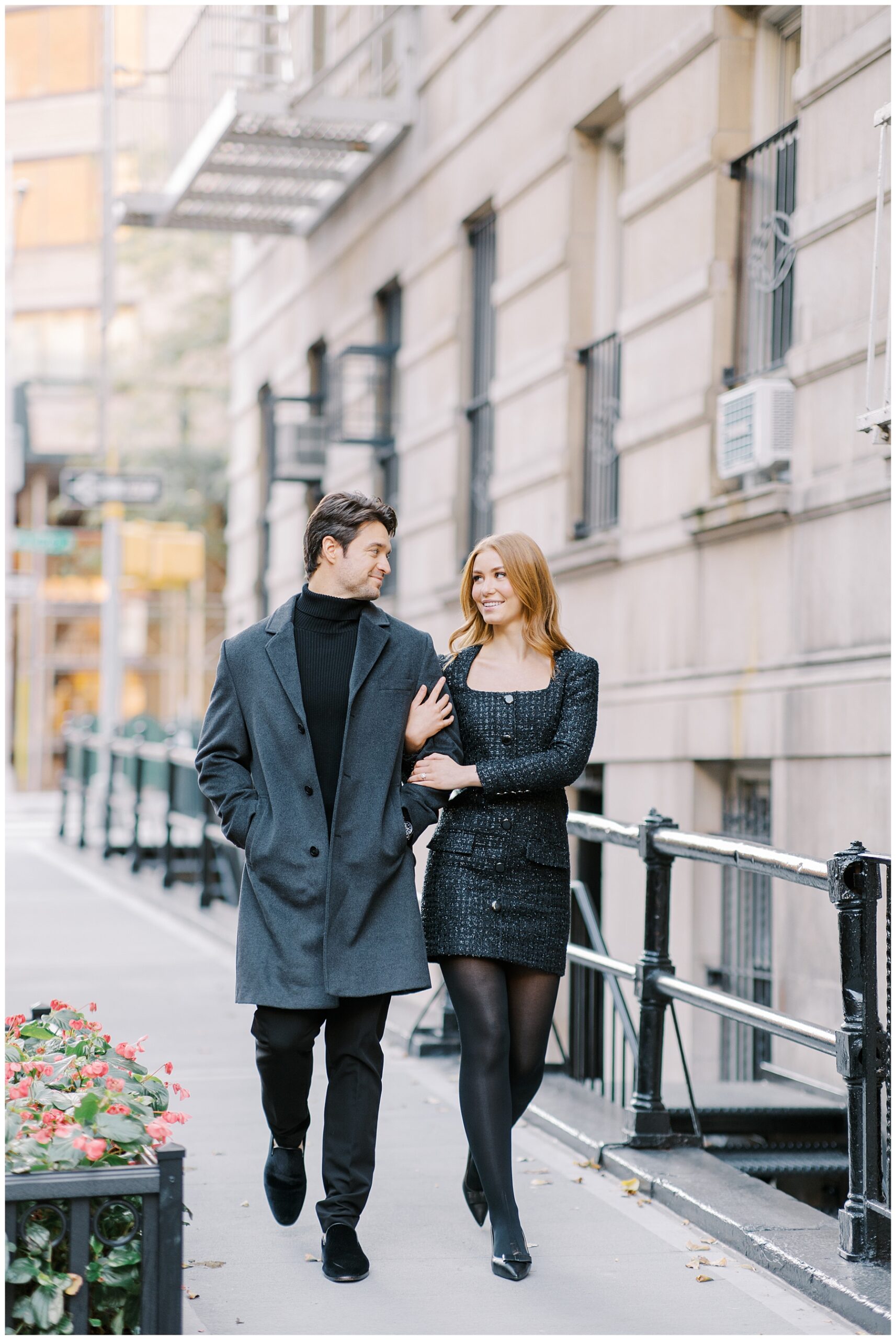 couple in high fashion, black outfits walk together down street in Upper East Side NY 