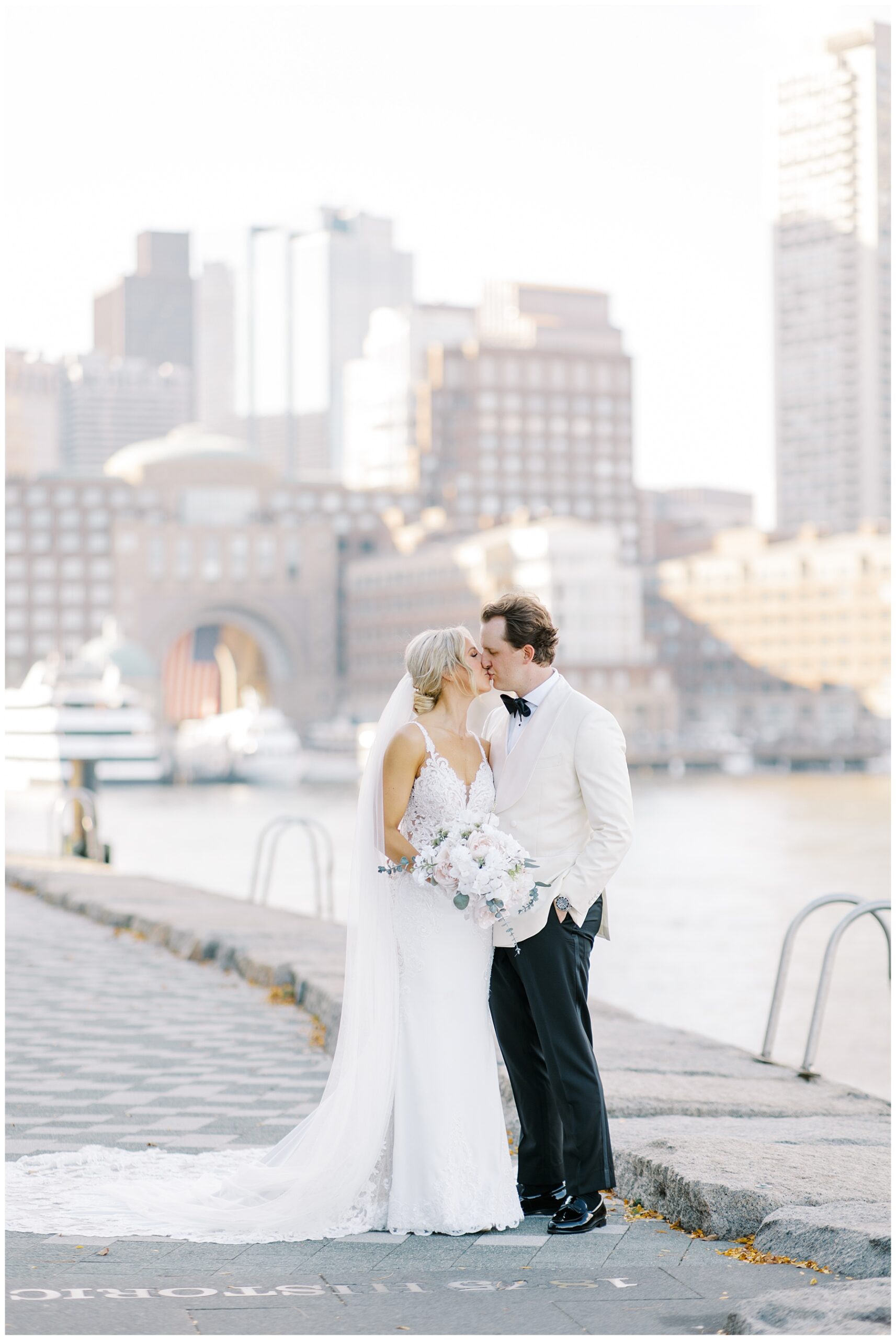 bride and groom kiss by the Boston Seaport