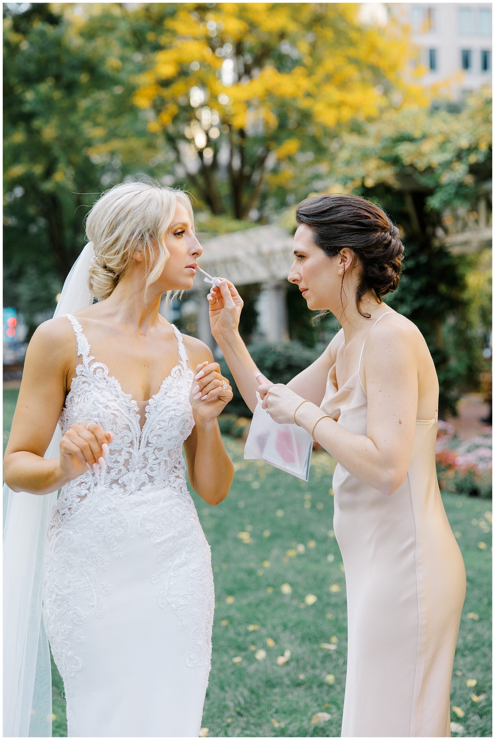 bridesmaid helping to touchup bride's makeup