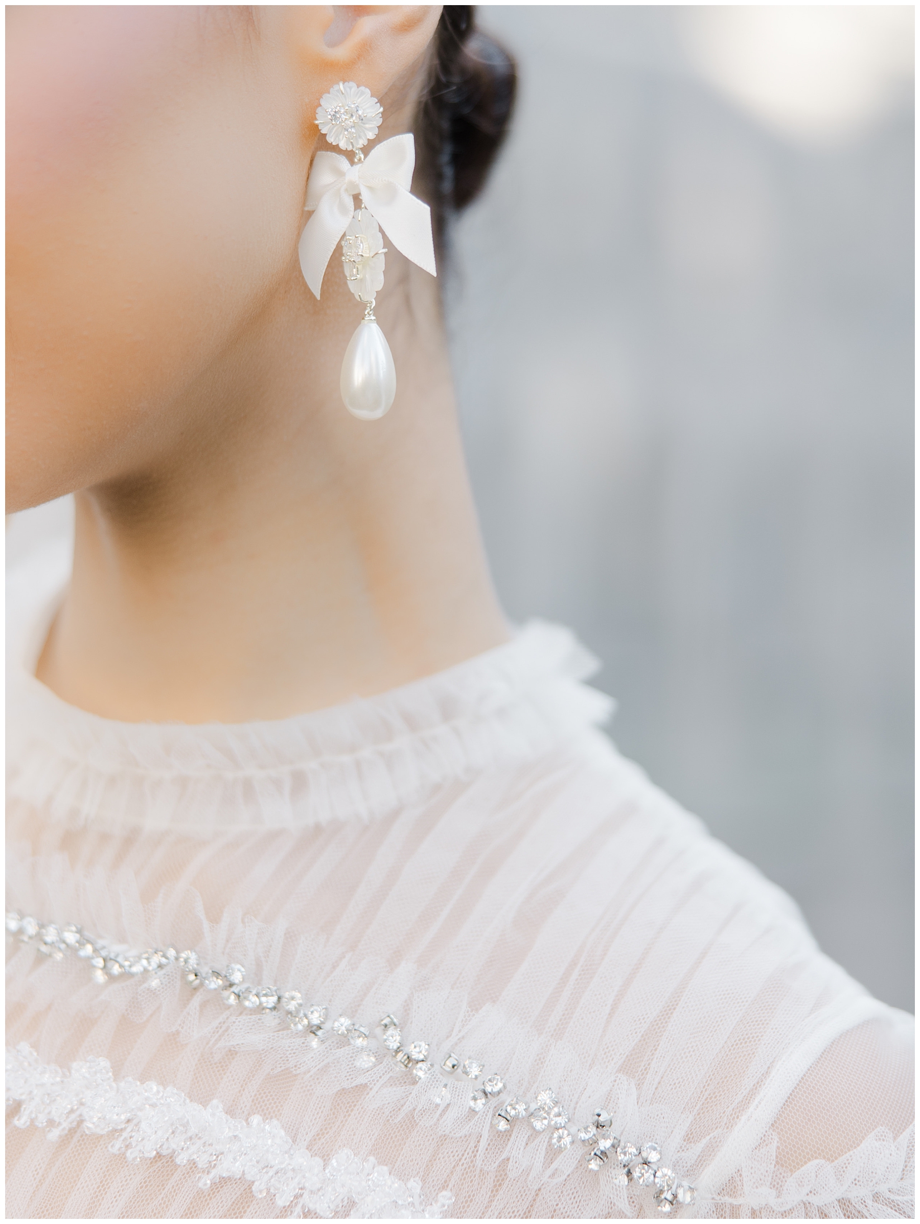 bride's earrings and detail of bride's wedding dress neckline 