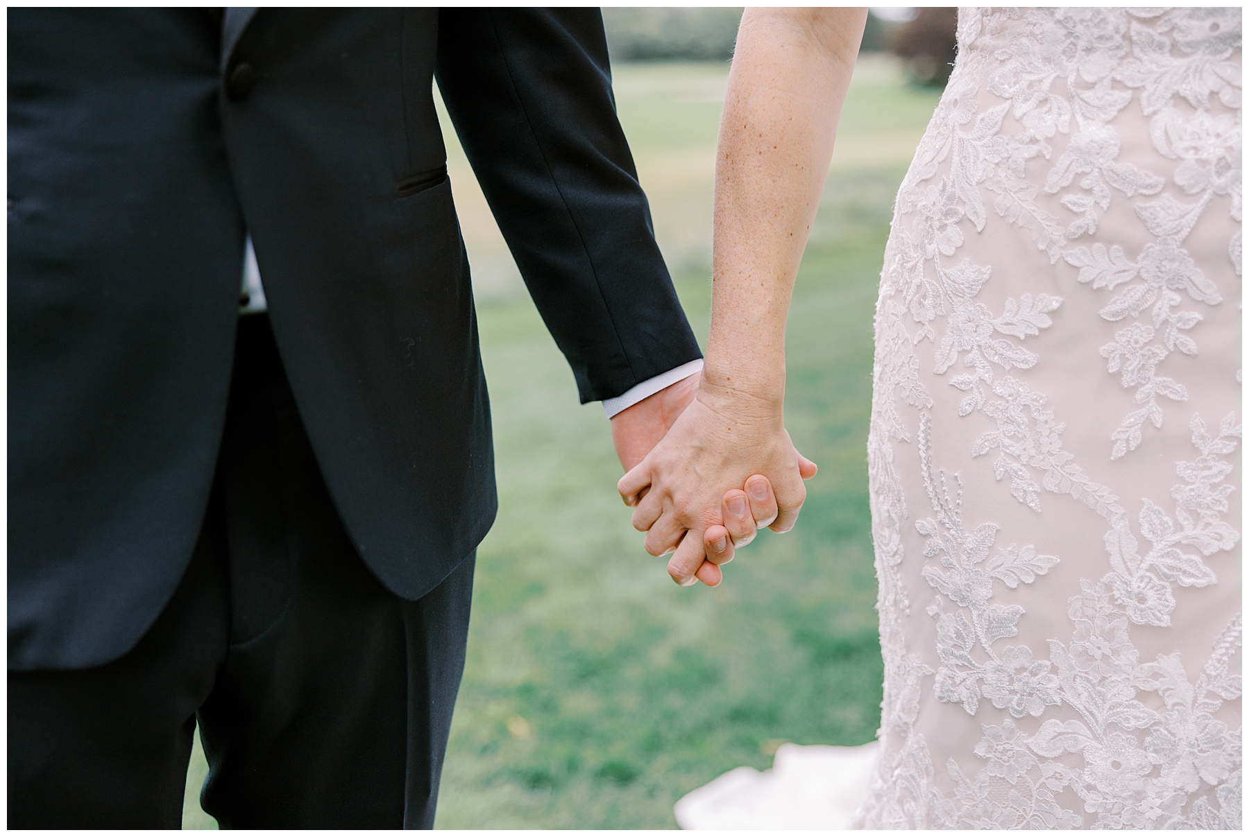 couple hold hands during wedding portraits 