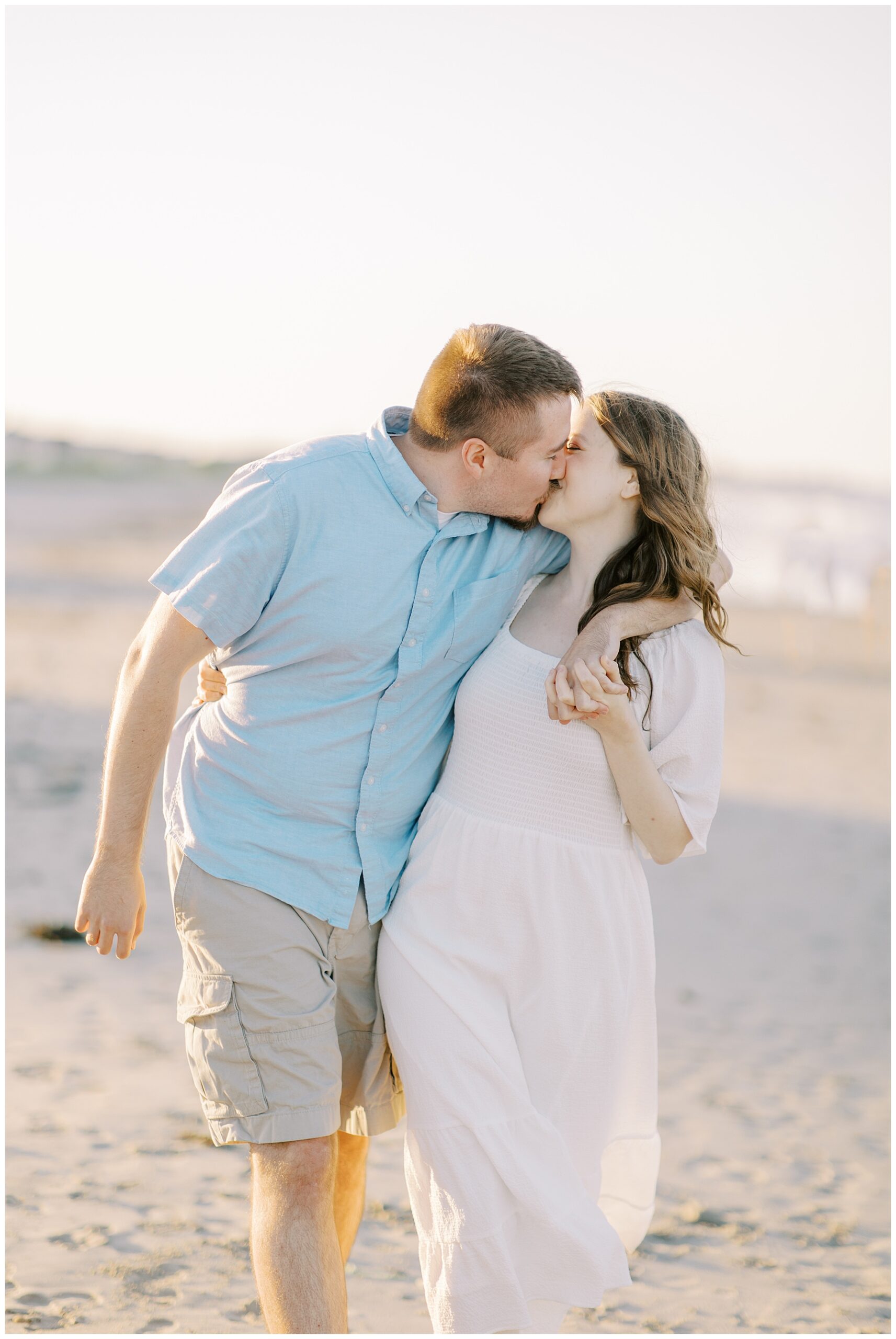 engaged couple steal a kiss during engagement session 