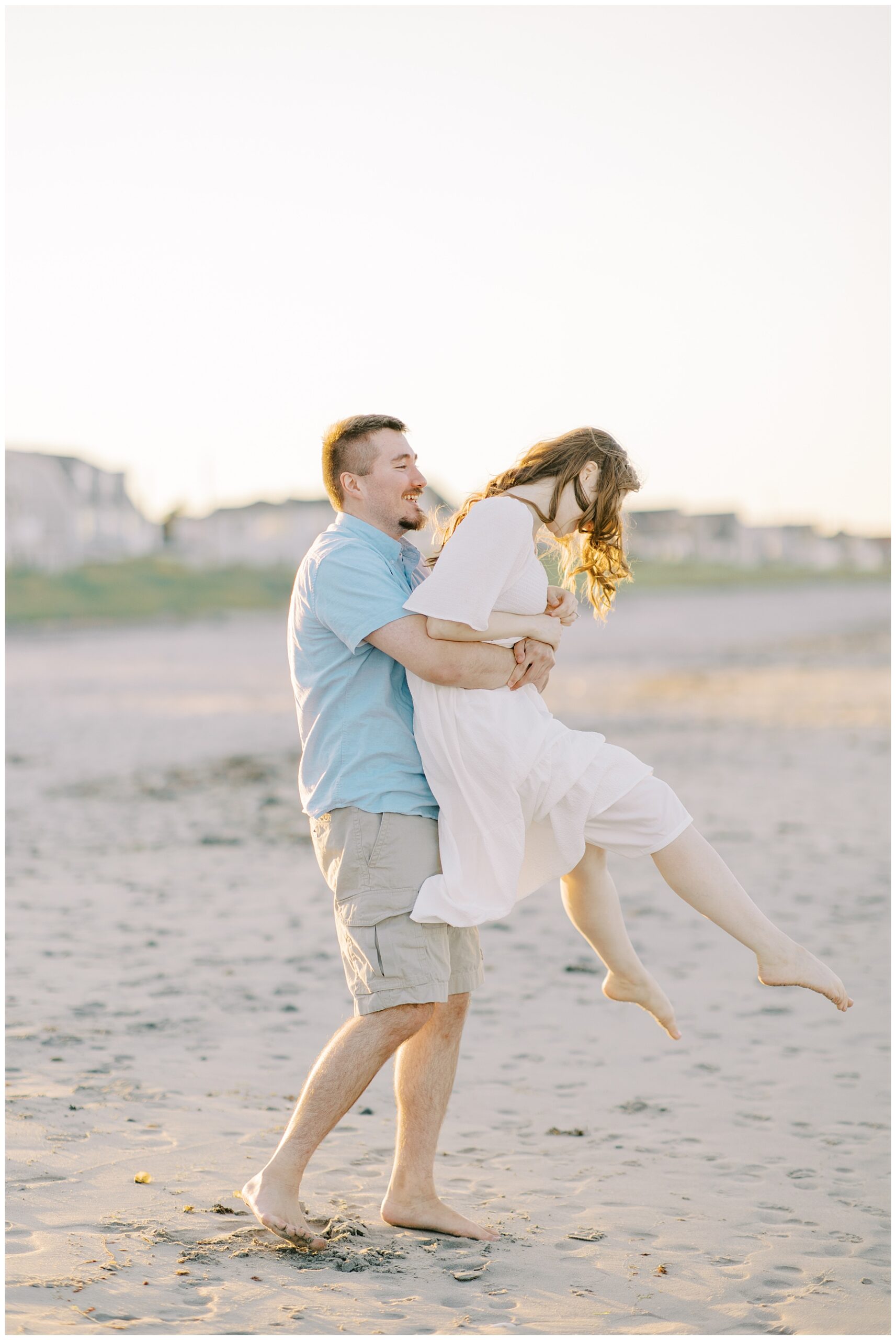 candid portraits of engaged couple having fun on the beach