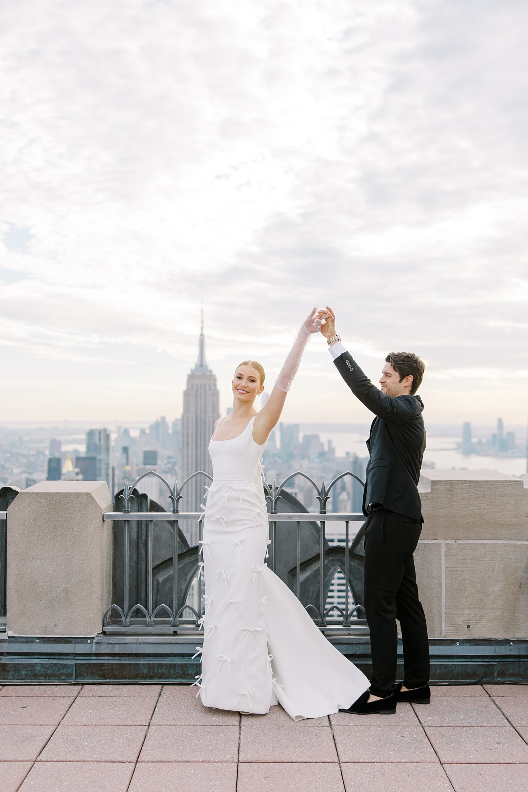newlyweds dance during wedding portraits at Top of the Rock