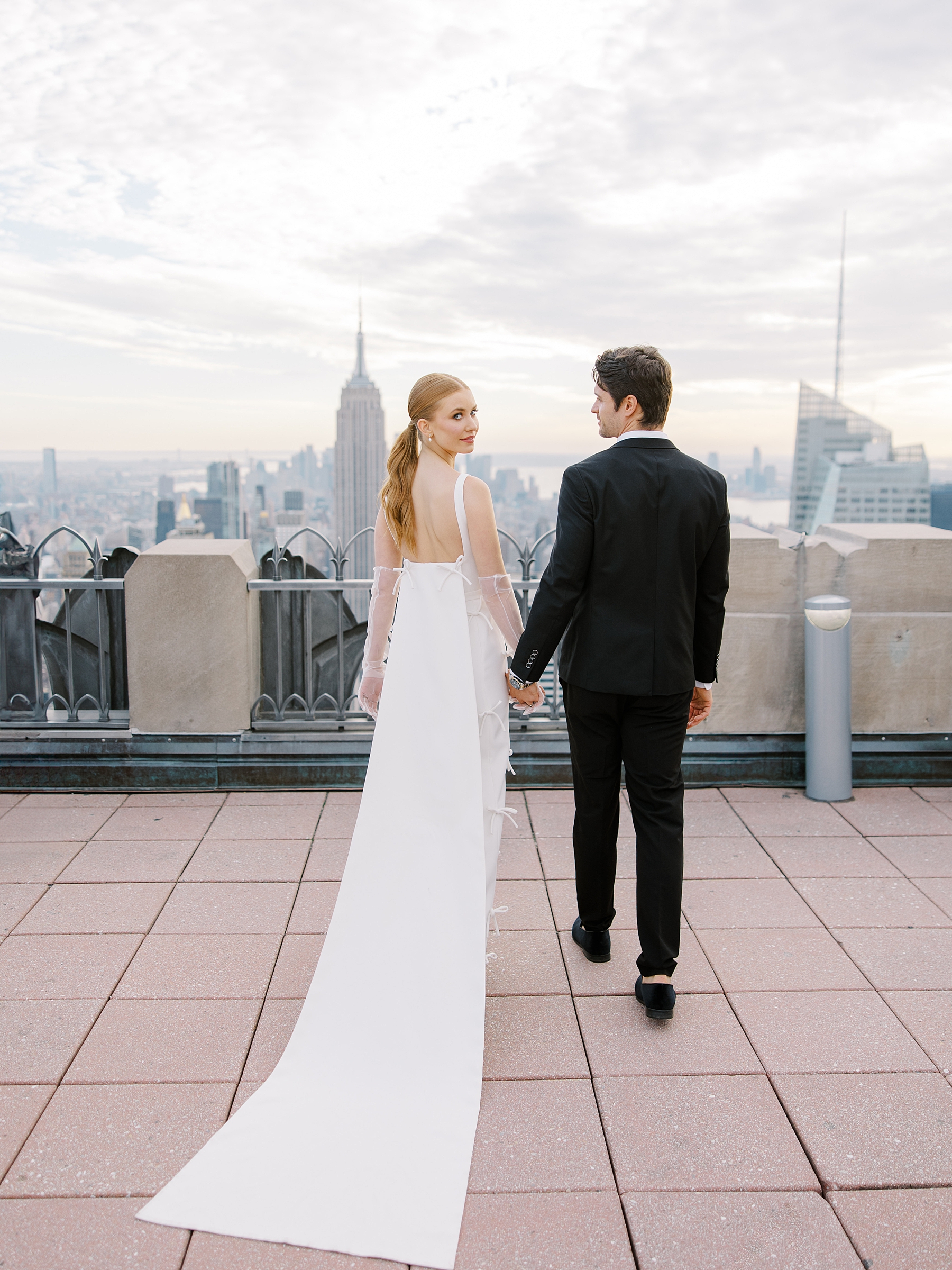bride and groom hold hands on rooftop in NYC