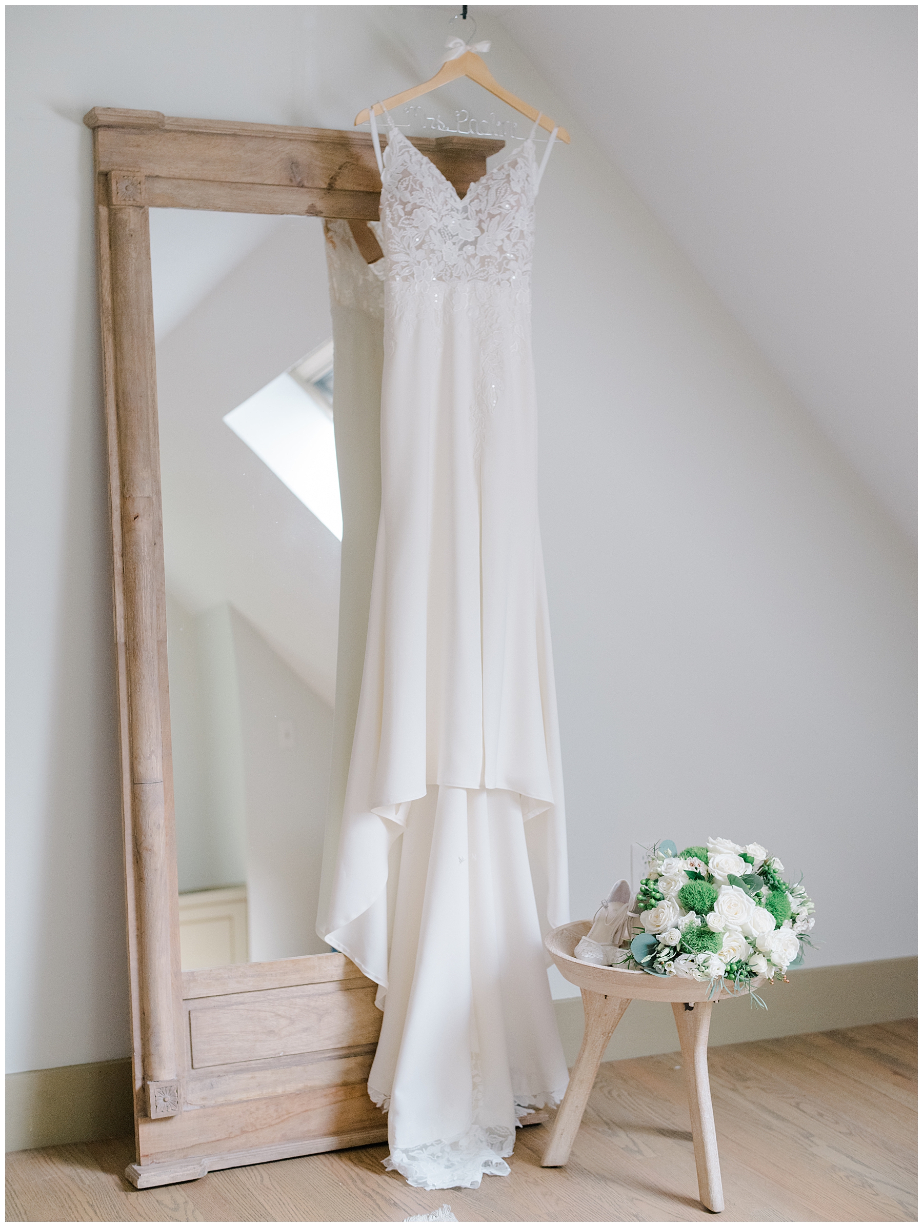 wedding dress hanging by mirror