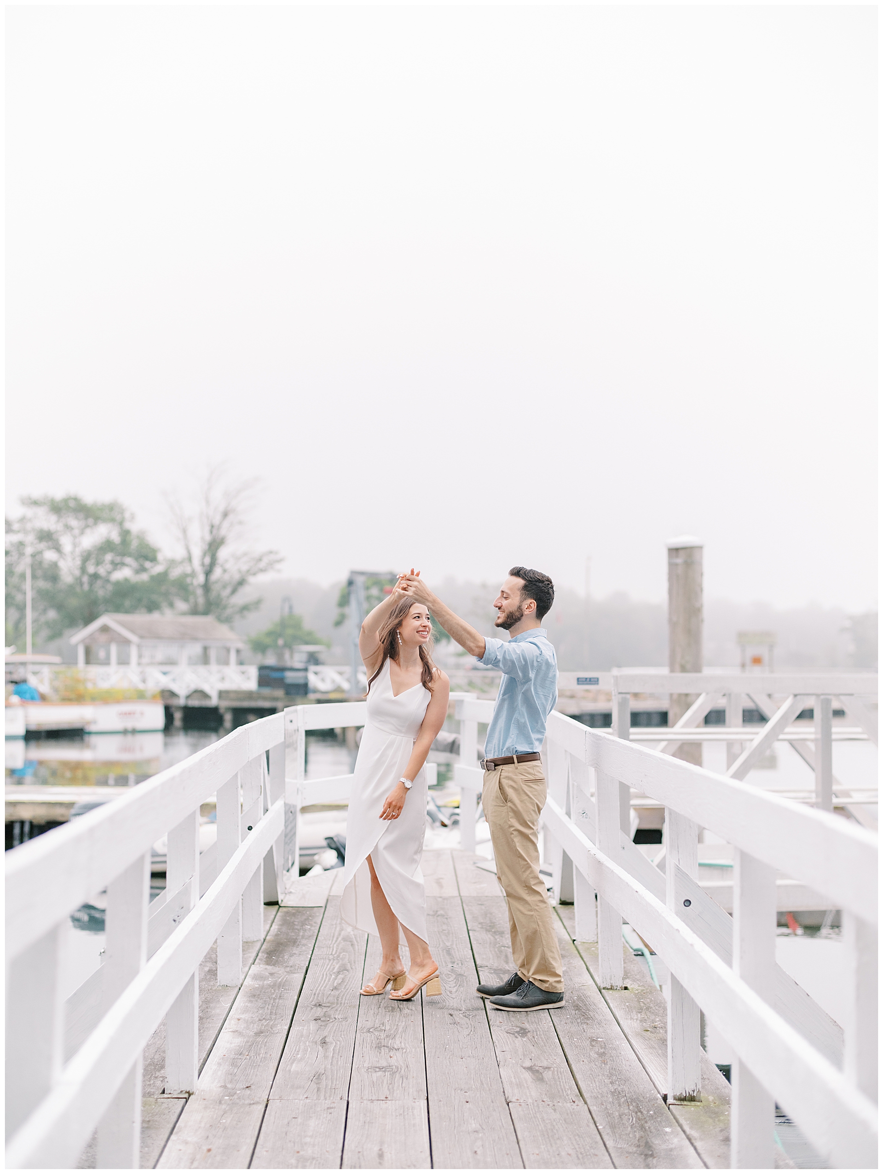engaged couple dance on the dock 