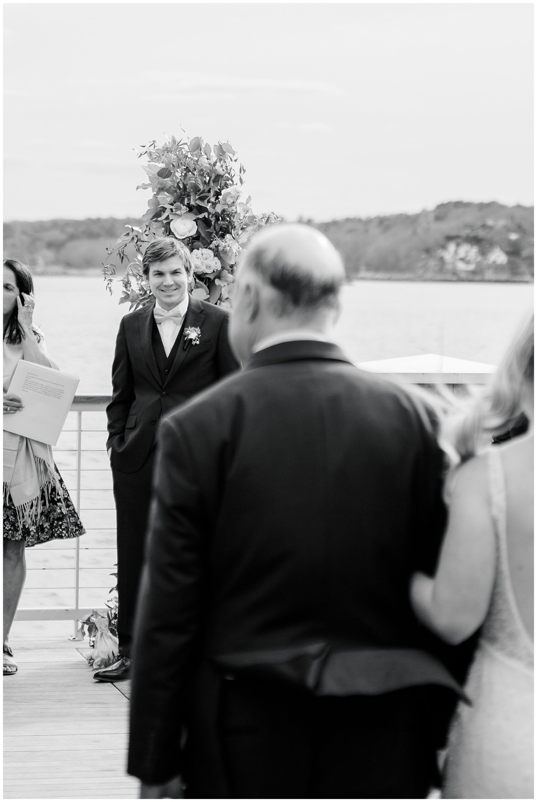 classic wedding moment of groom watching bride walk down the aisle 