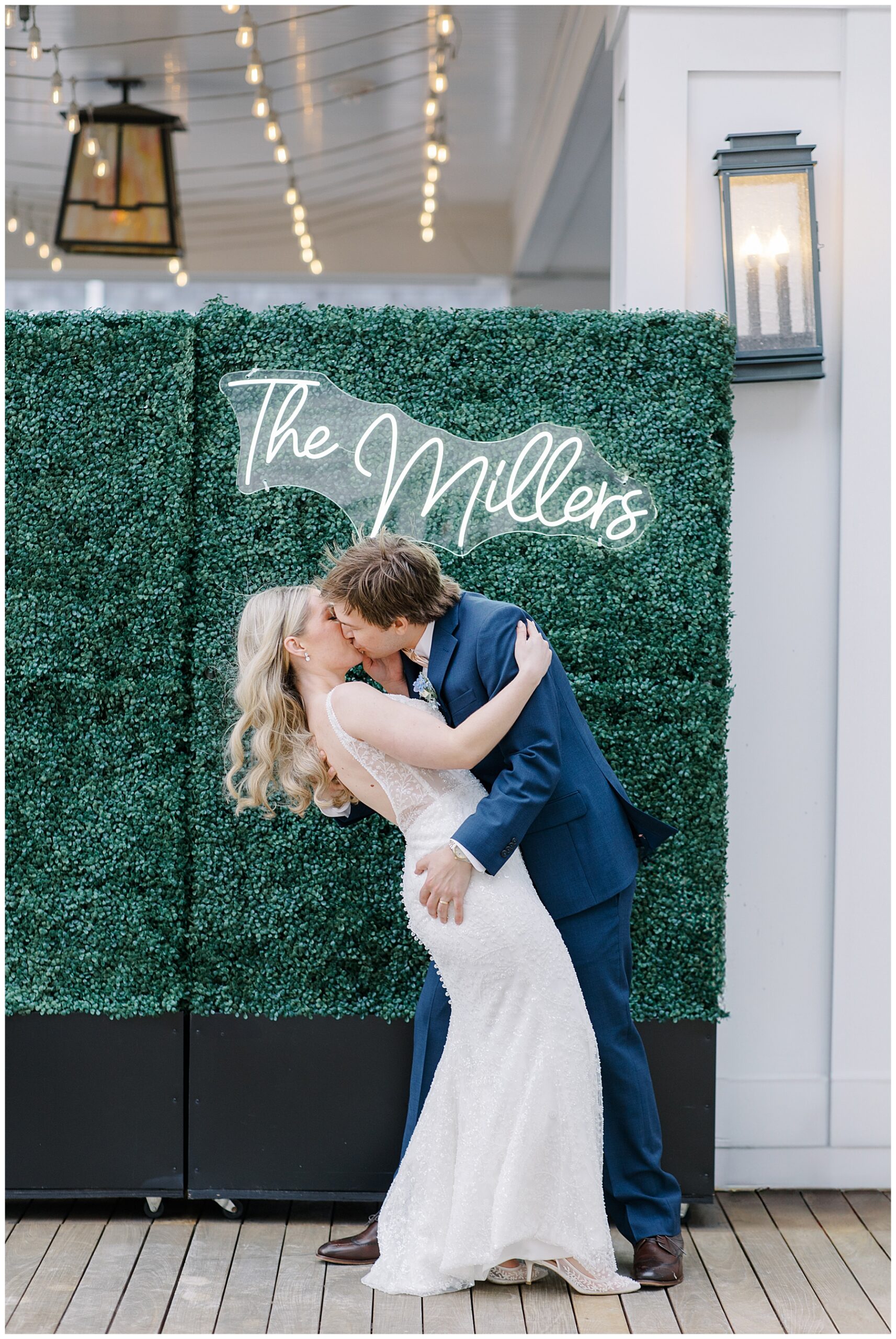 newlyweds kiss under light-up last name sign