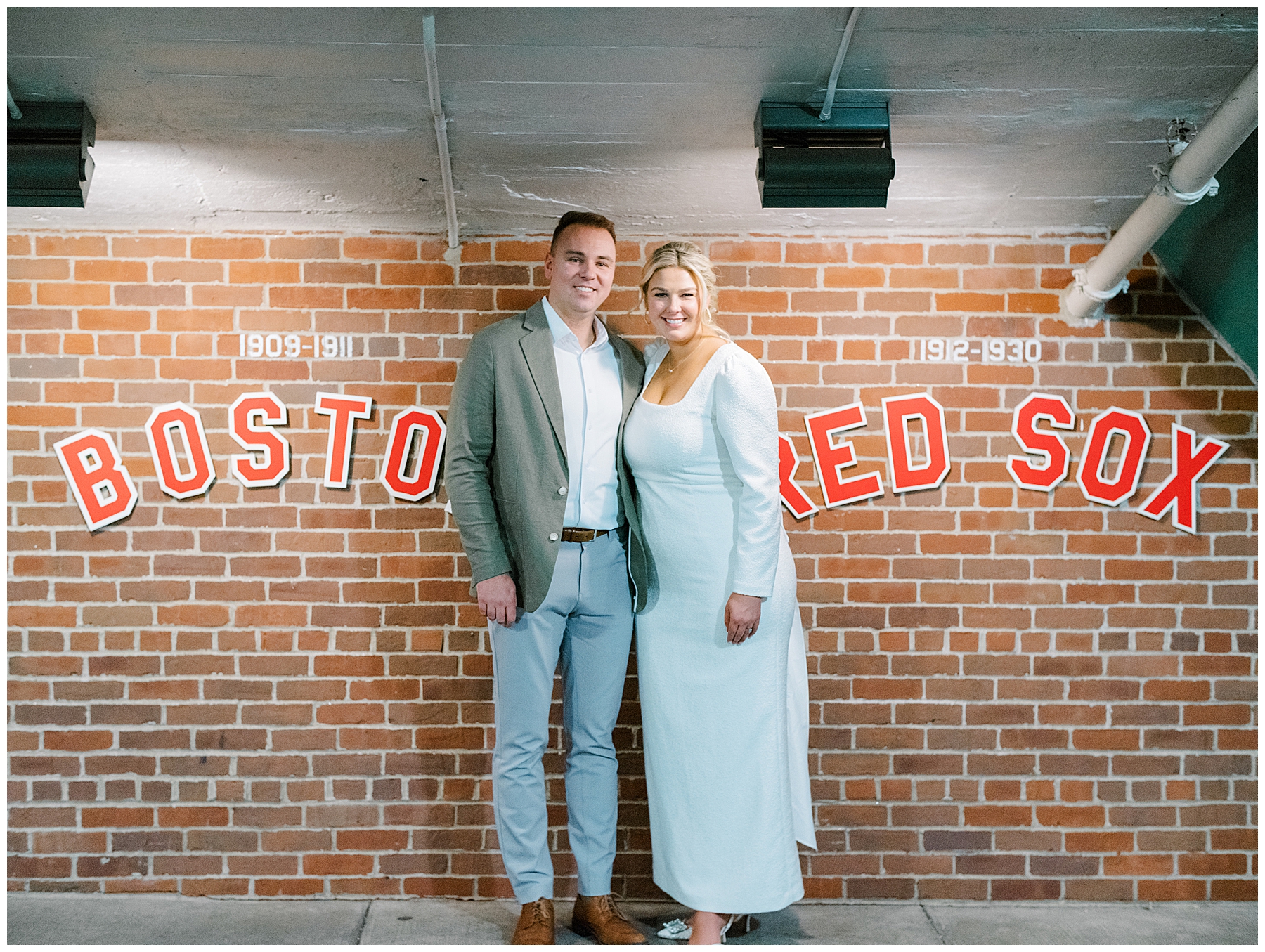 couple photos stand by Boston Red Sox sign