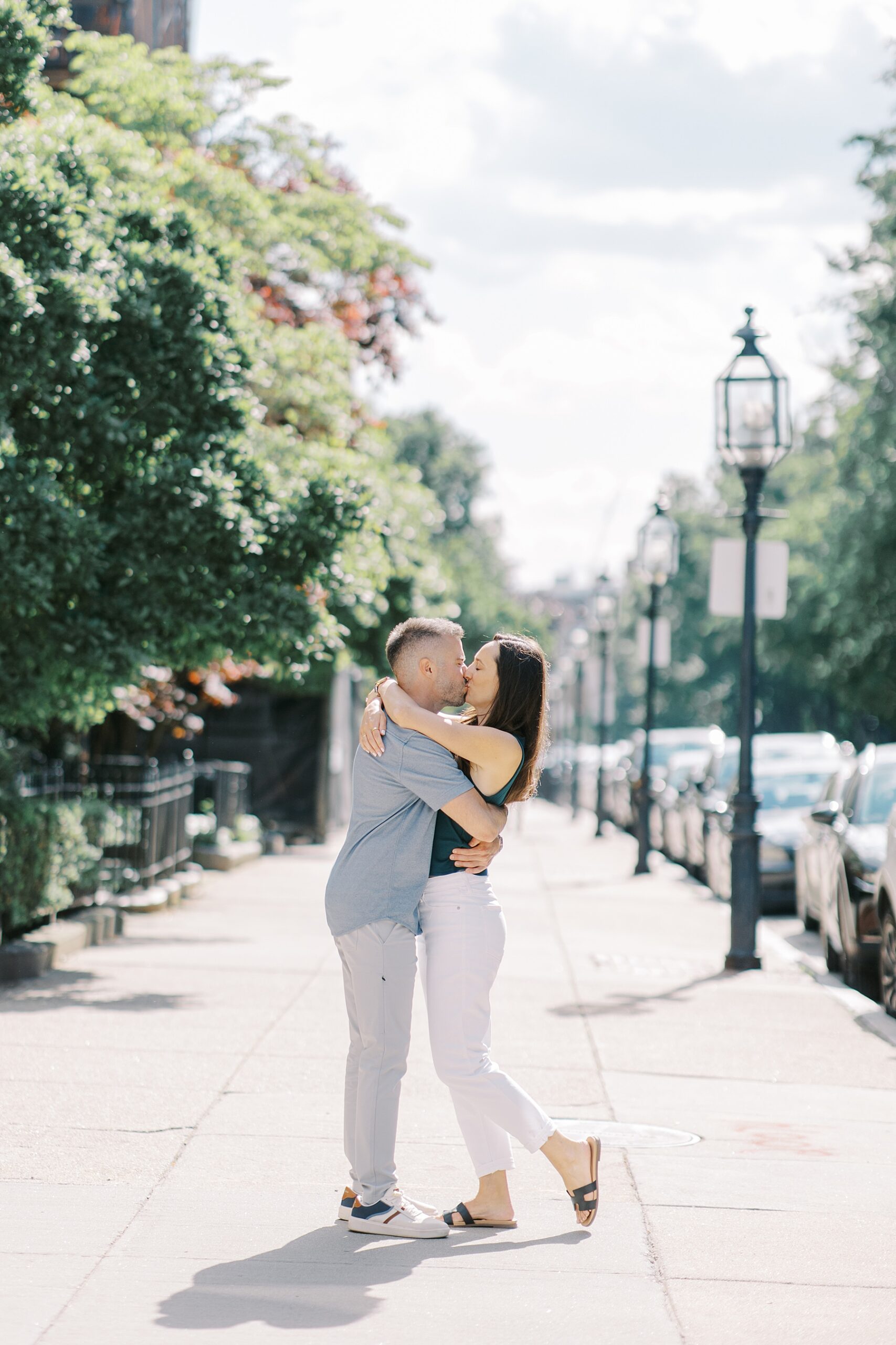 newly engaged couple kiss in Boston street after Epic Rooftop Proposal in Boston