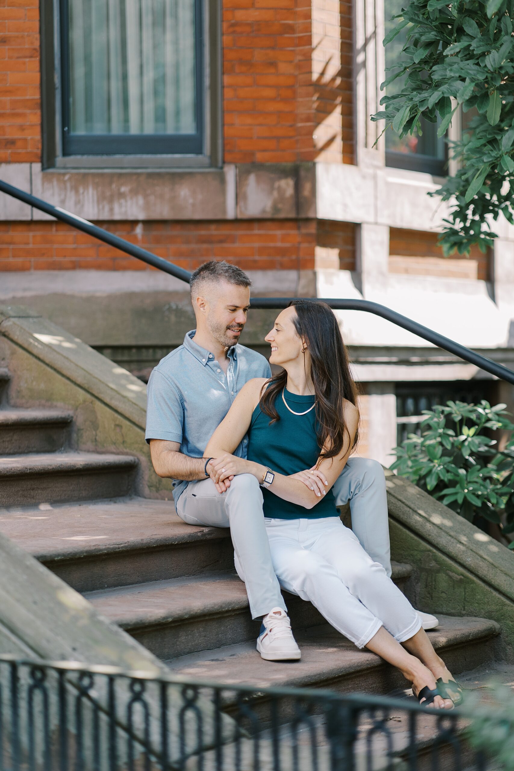 newly engaged couple sit on stairs in Boston 