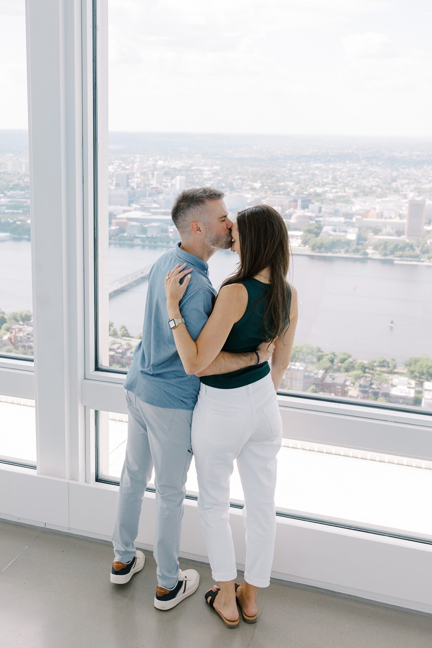 romantic portrait of couple kissing as they look at the Boston skyline