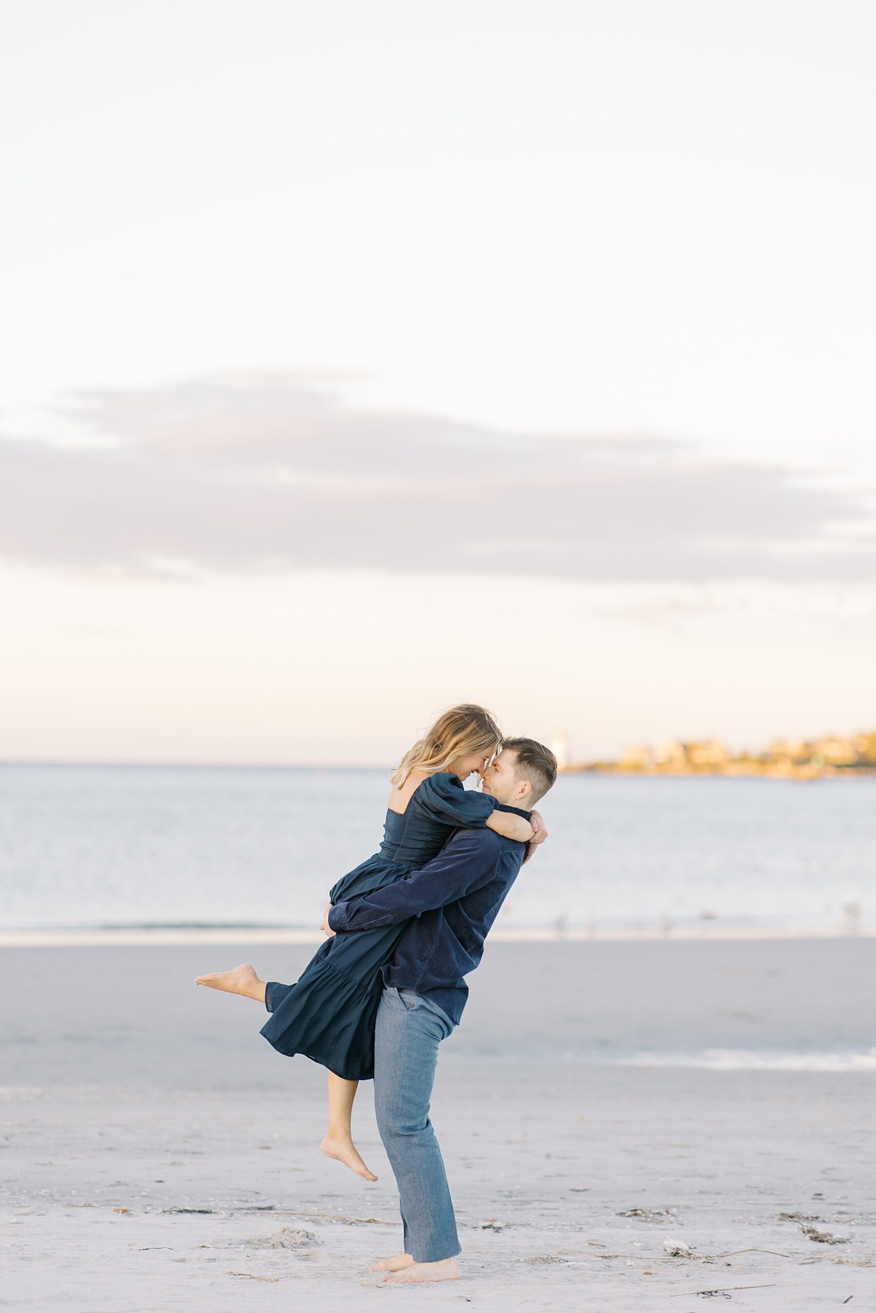 Man lifts his fiance up during engagement session