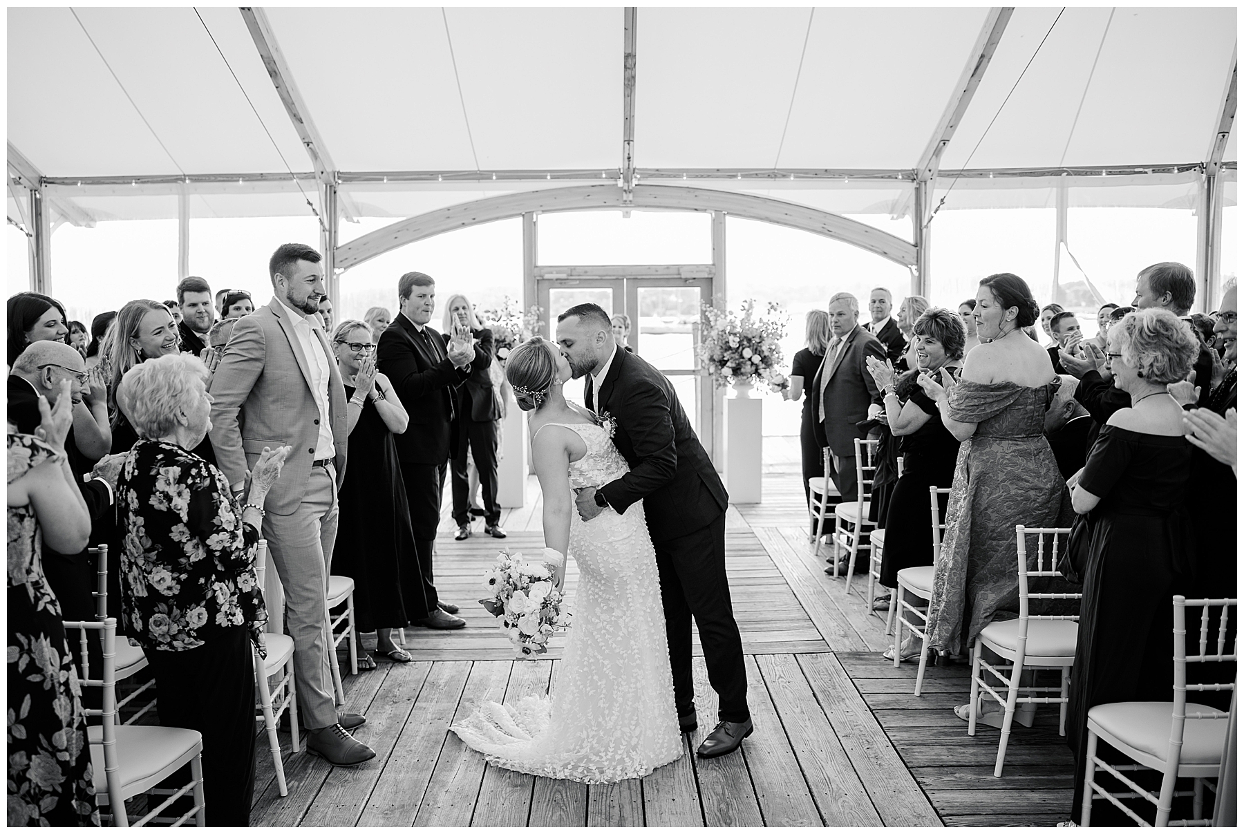 couple kiss as they walk down the aisle 