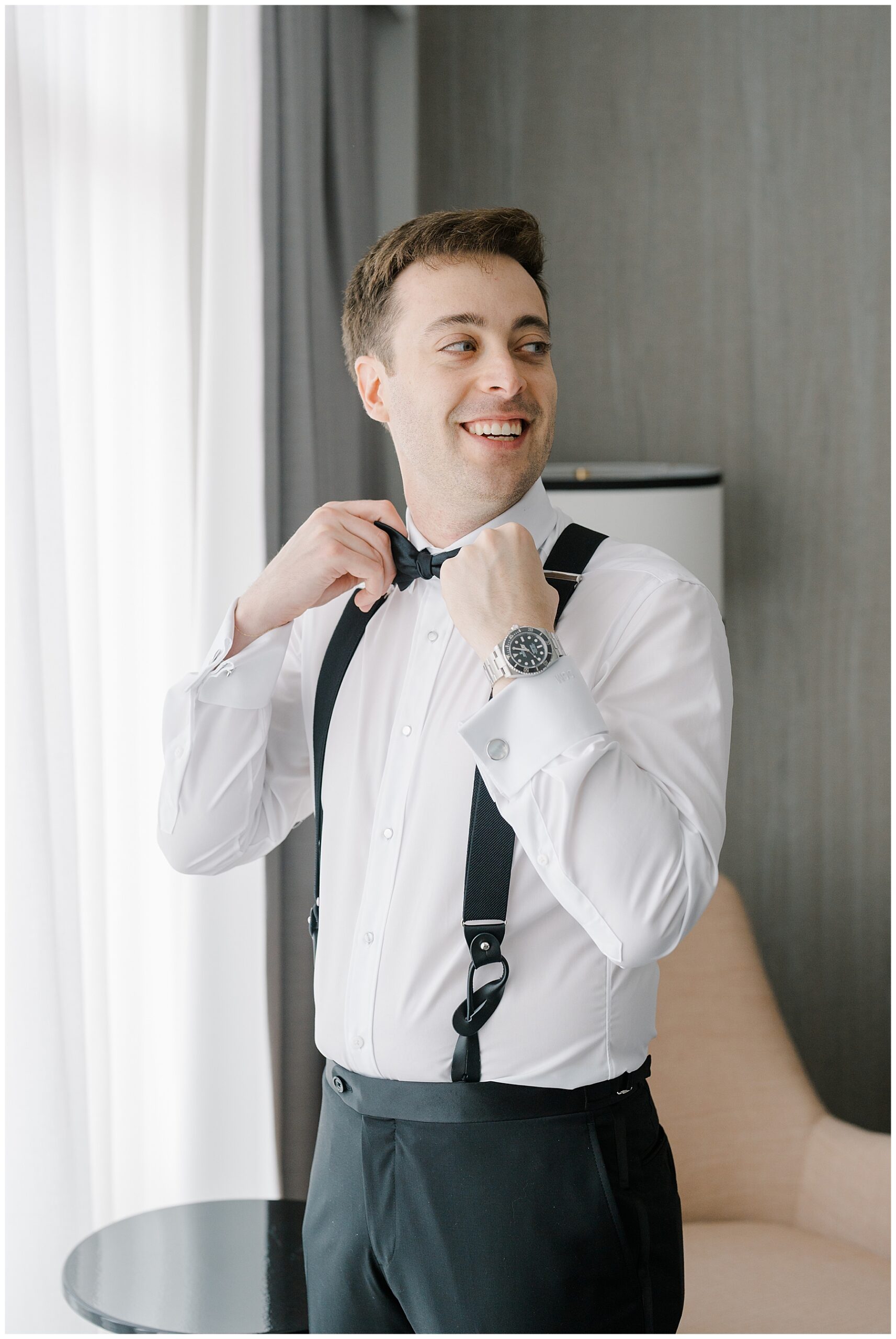 groom putting bowtie on