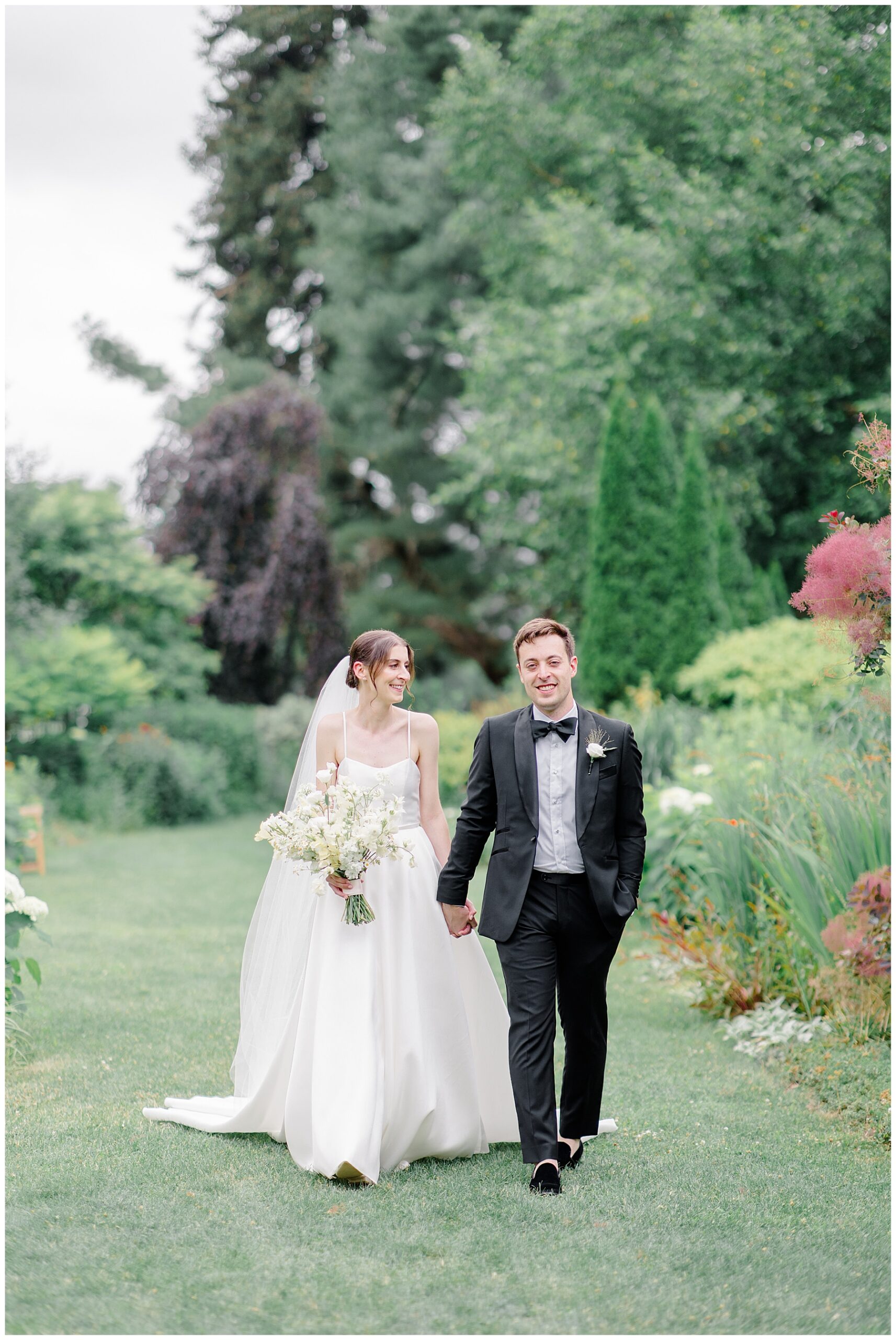 bride and groom hold hands as they walk the stunning gardens at The Gardens at Elm Bank  