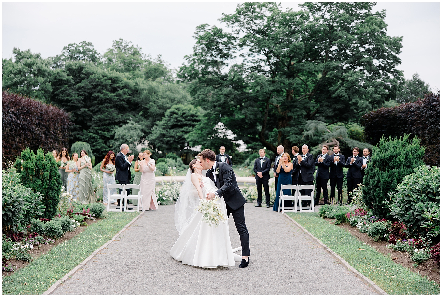 groom kisses bride as they walk down the aisle together