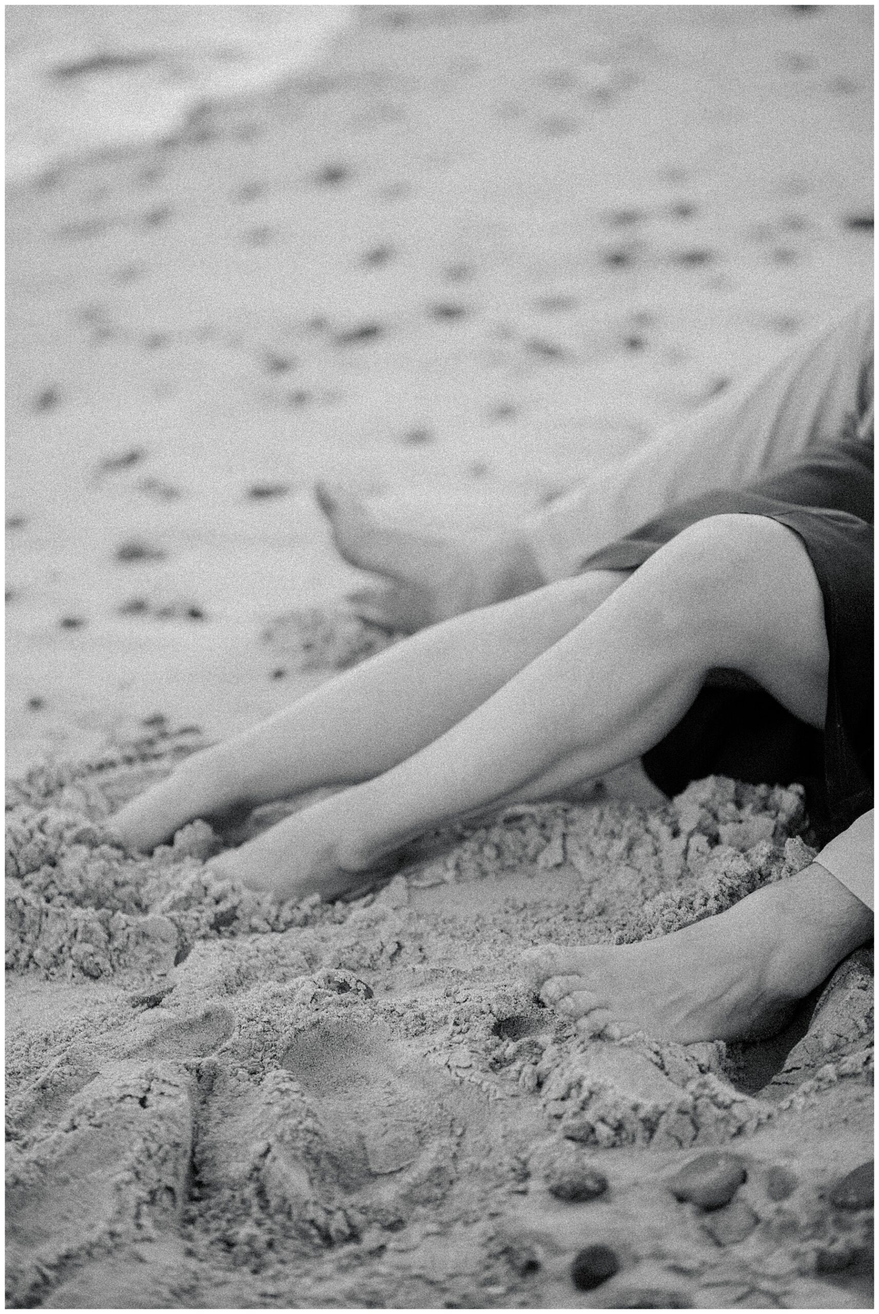 couple's legs and feet in the sand