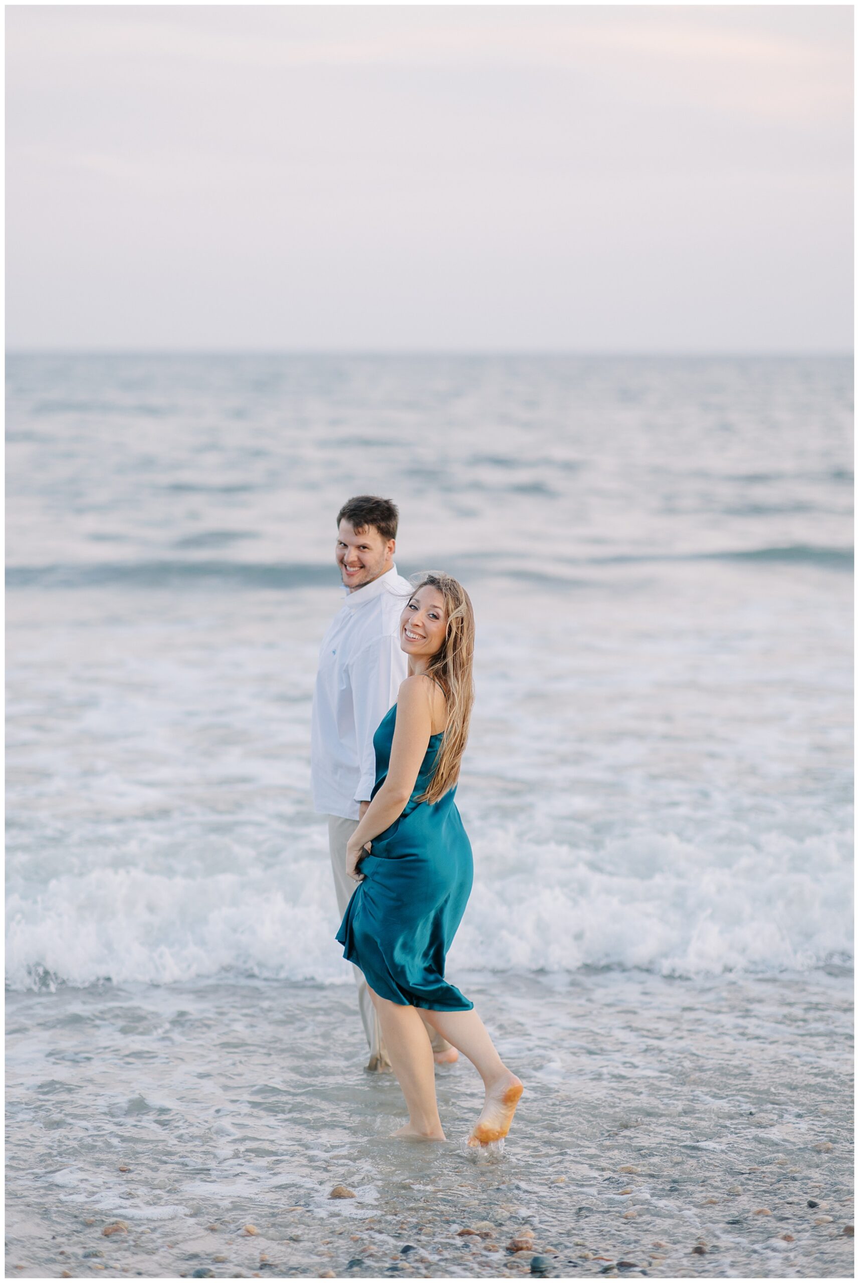 couple walk in the waves of ocean