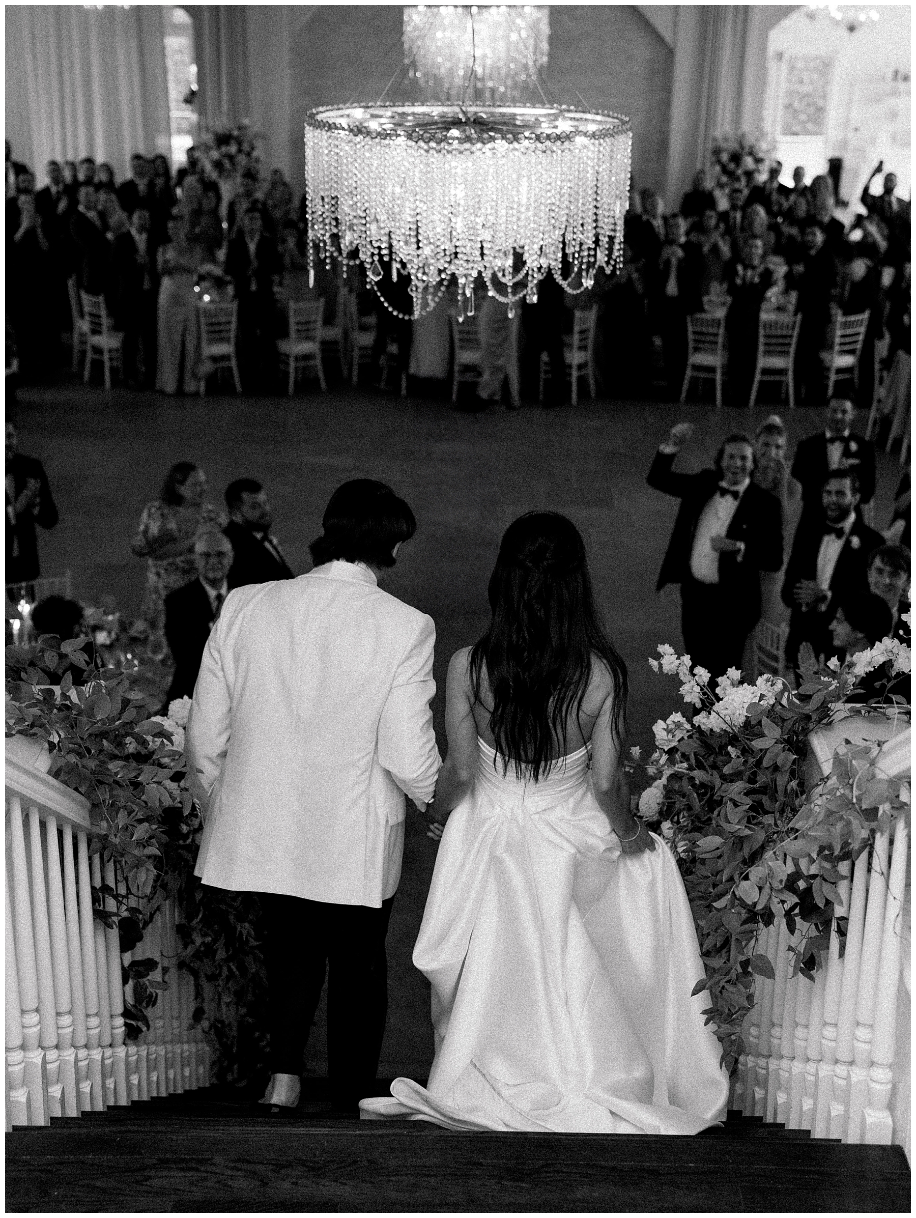 newlyweds walk down staircase to reception
