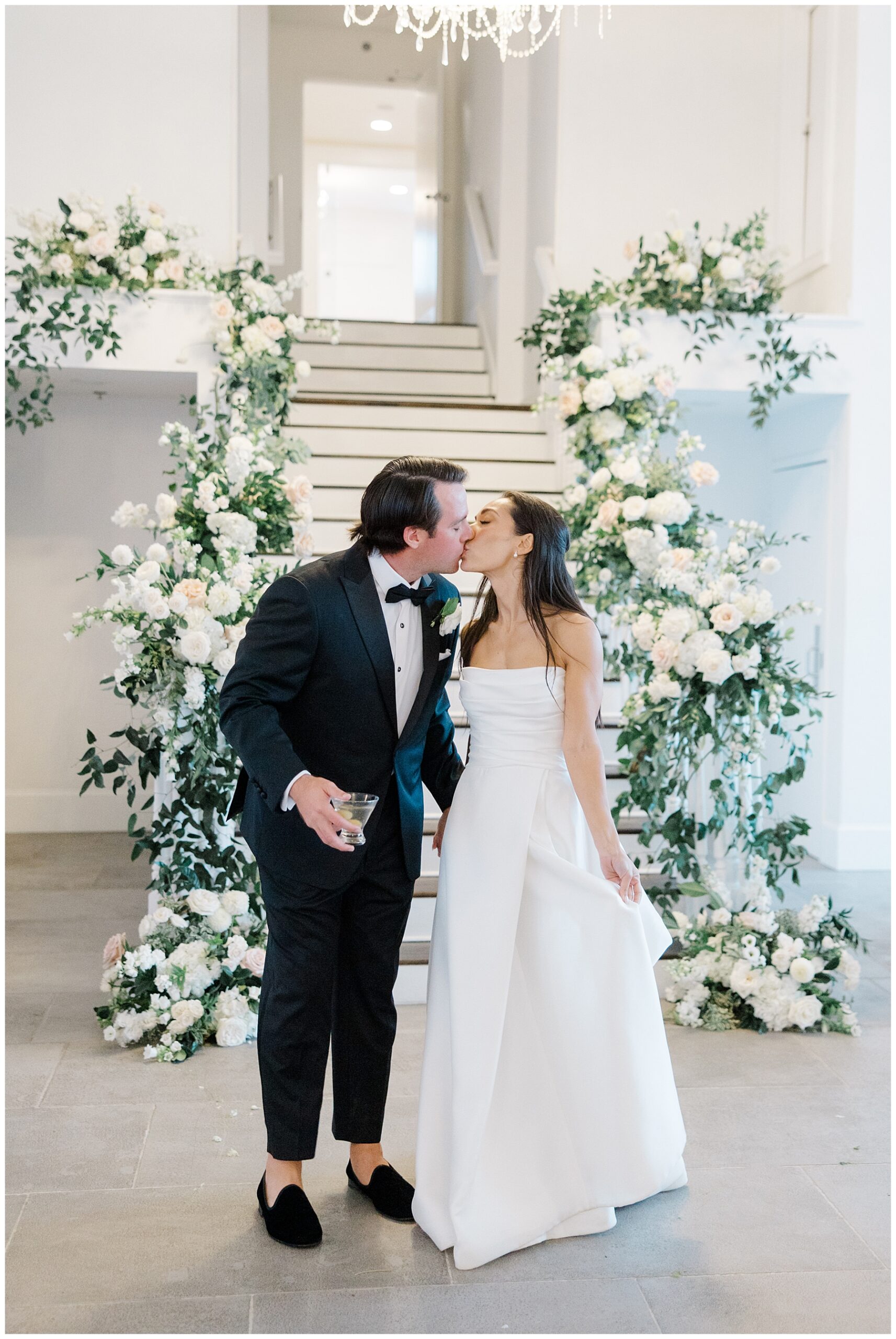 bride and groom kiss at the bottom of stairs