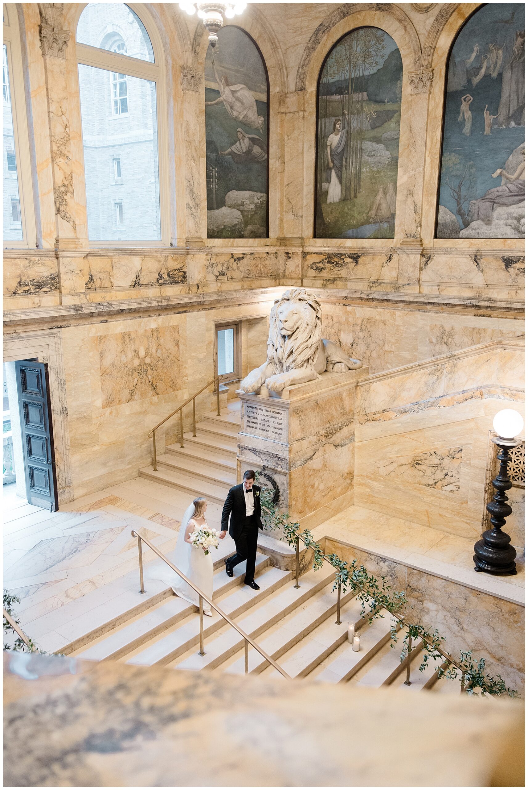 newlyweds walk down grand staircase of the BPL with iconic lion statues