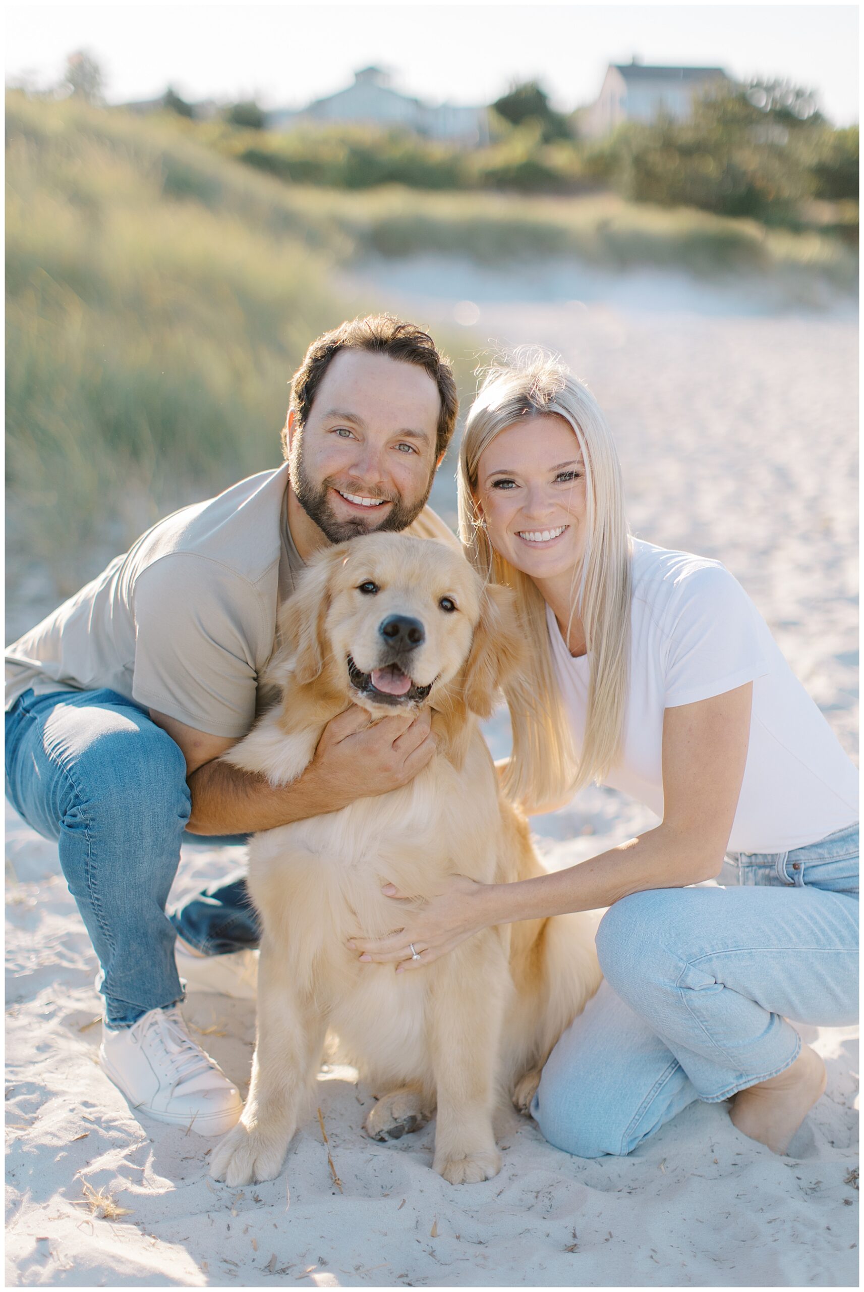 couple with their golden retriever on the beach