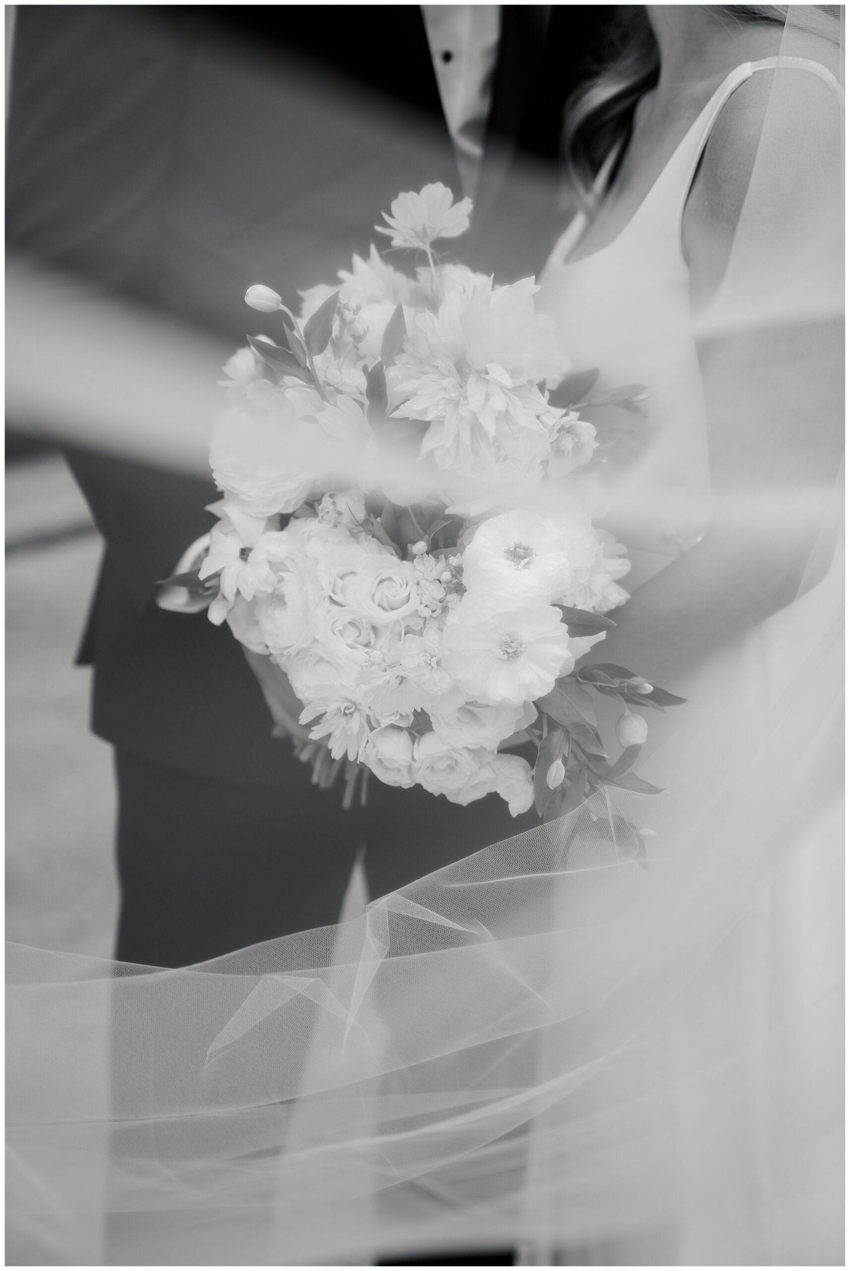 black and white photo of bride and groom with bridal bouquet