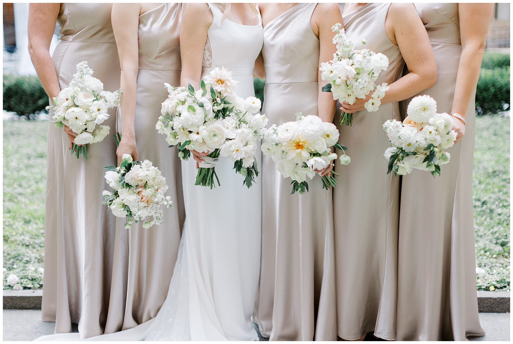 elegant bridesmaids in champagne dresses stand with bride holding white bouquets
