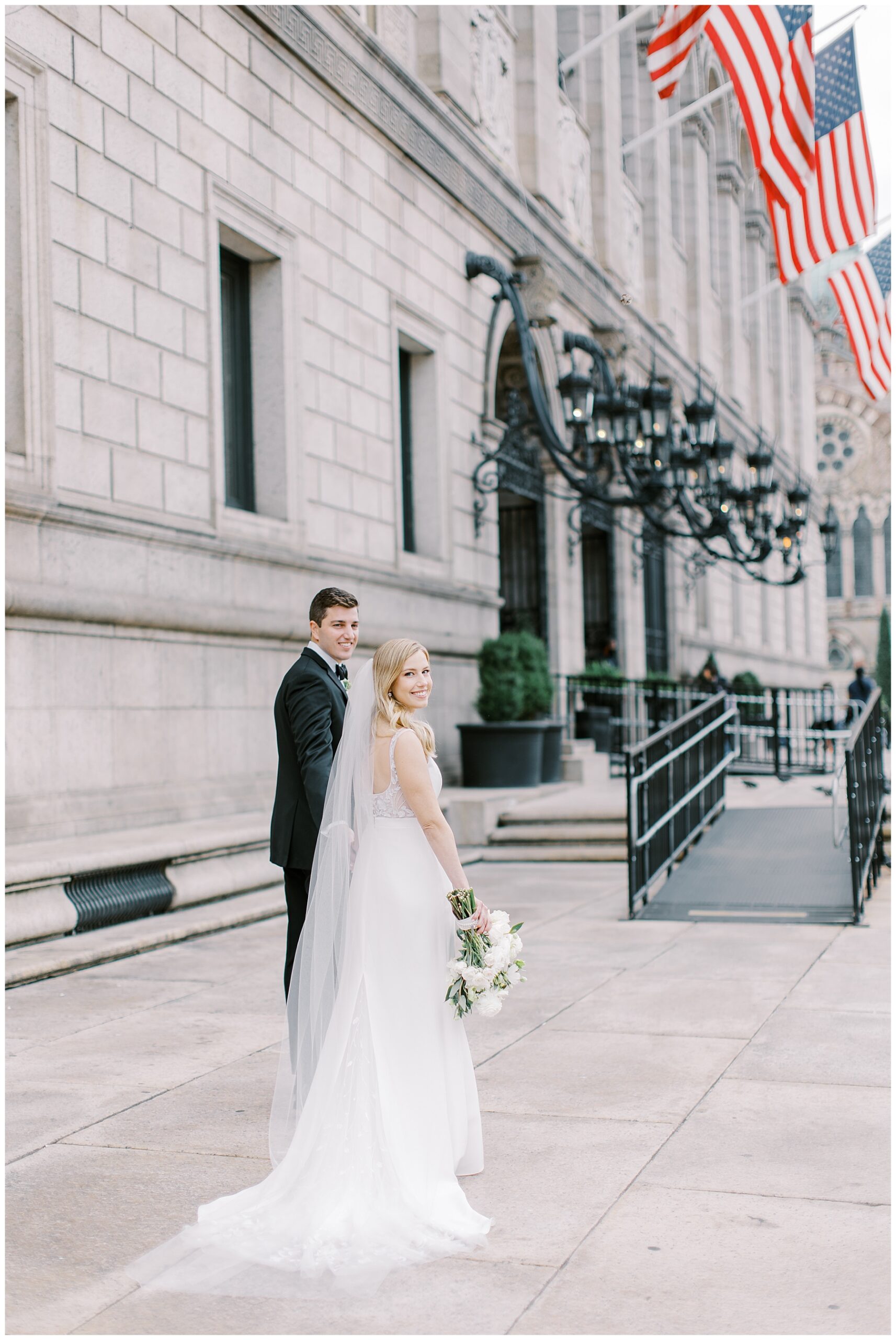 newlyweds walk together outside of the Boston Public Library
