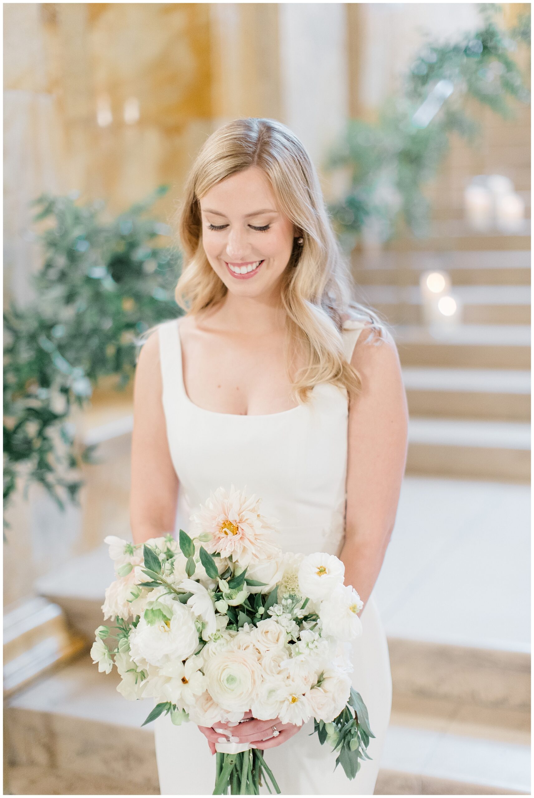 bride in white fitted wedding gown holding elegant white bouquet