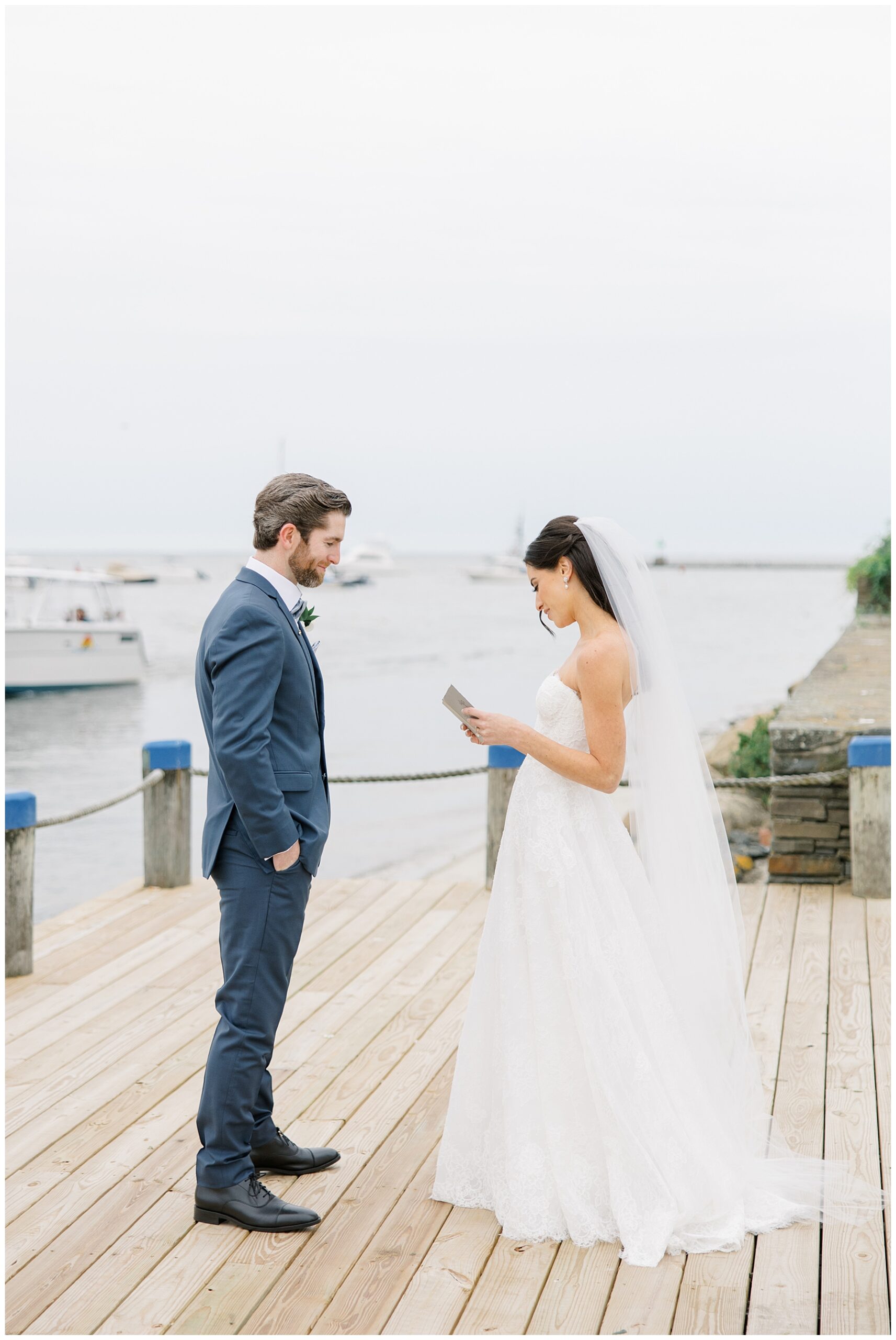 couple reads private vows on dock by the water