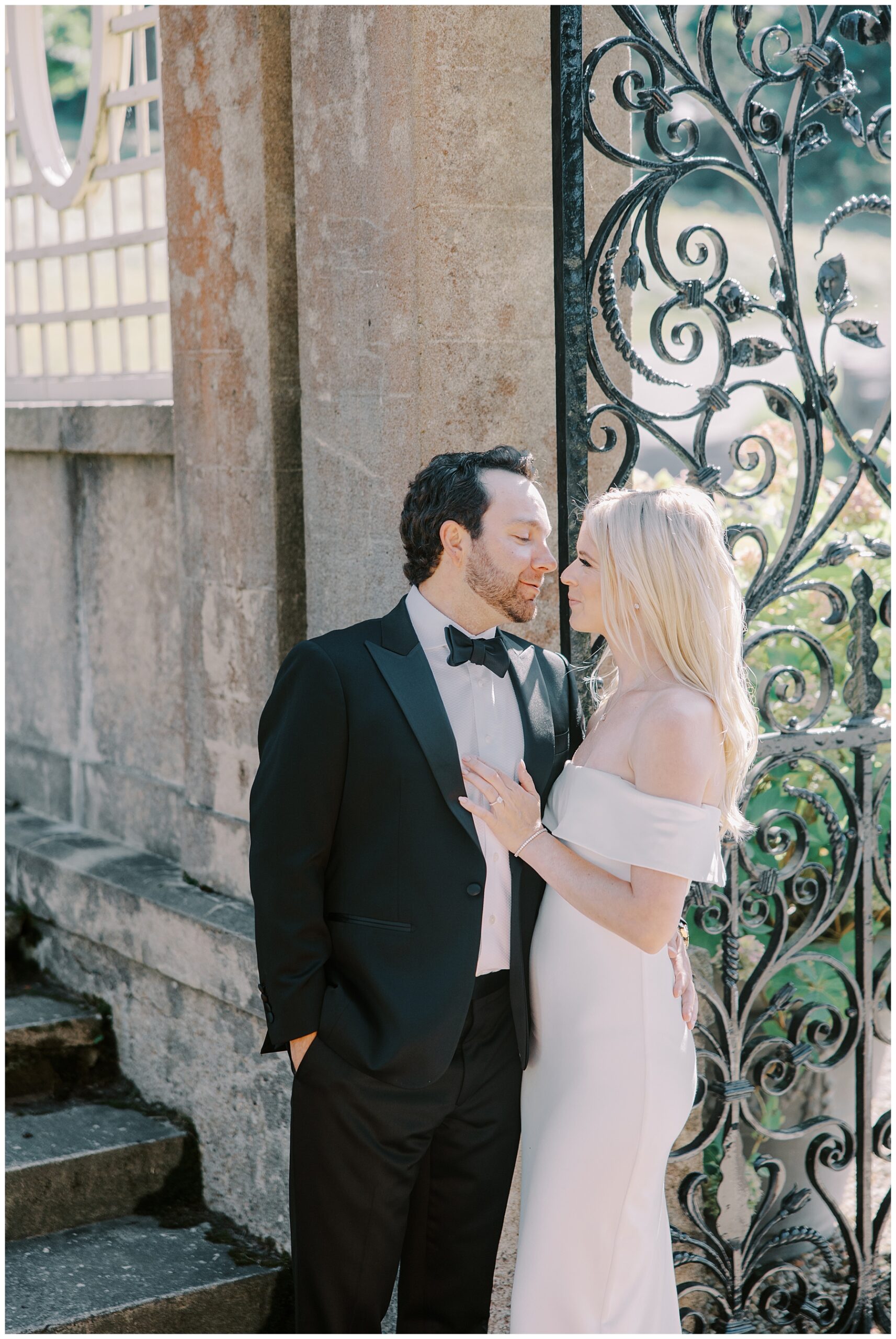 couple kiss by gate of estate
