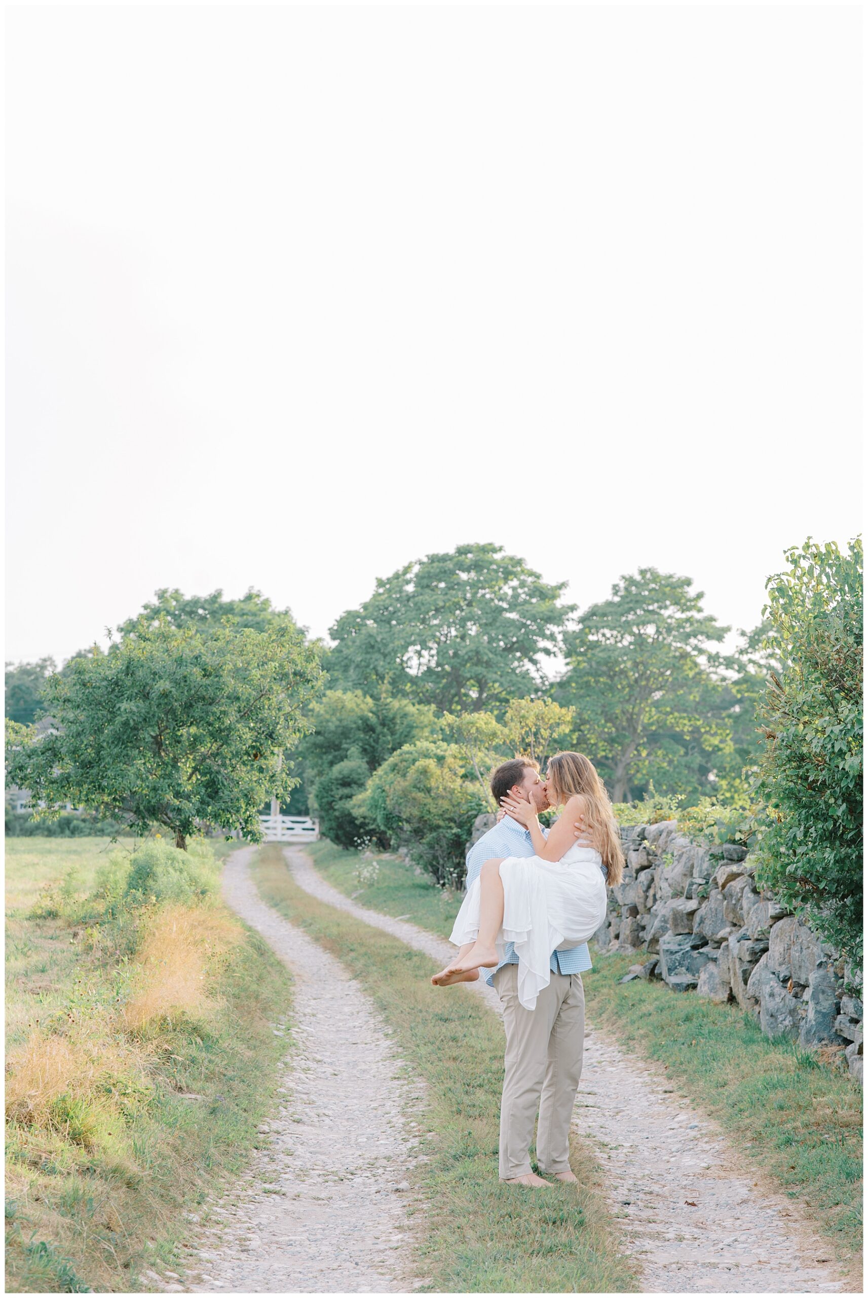 couple kiss as man carries woman in arms