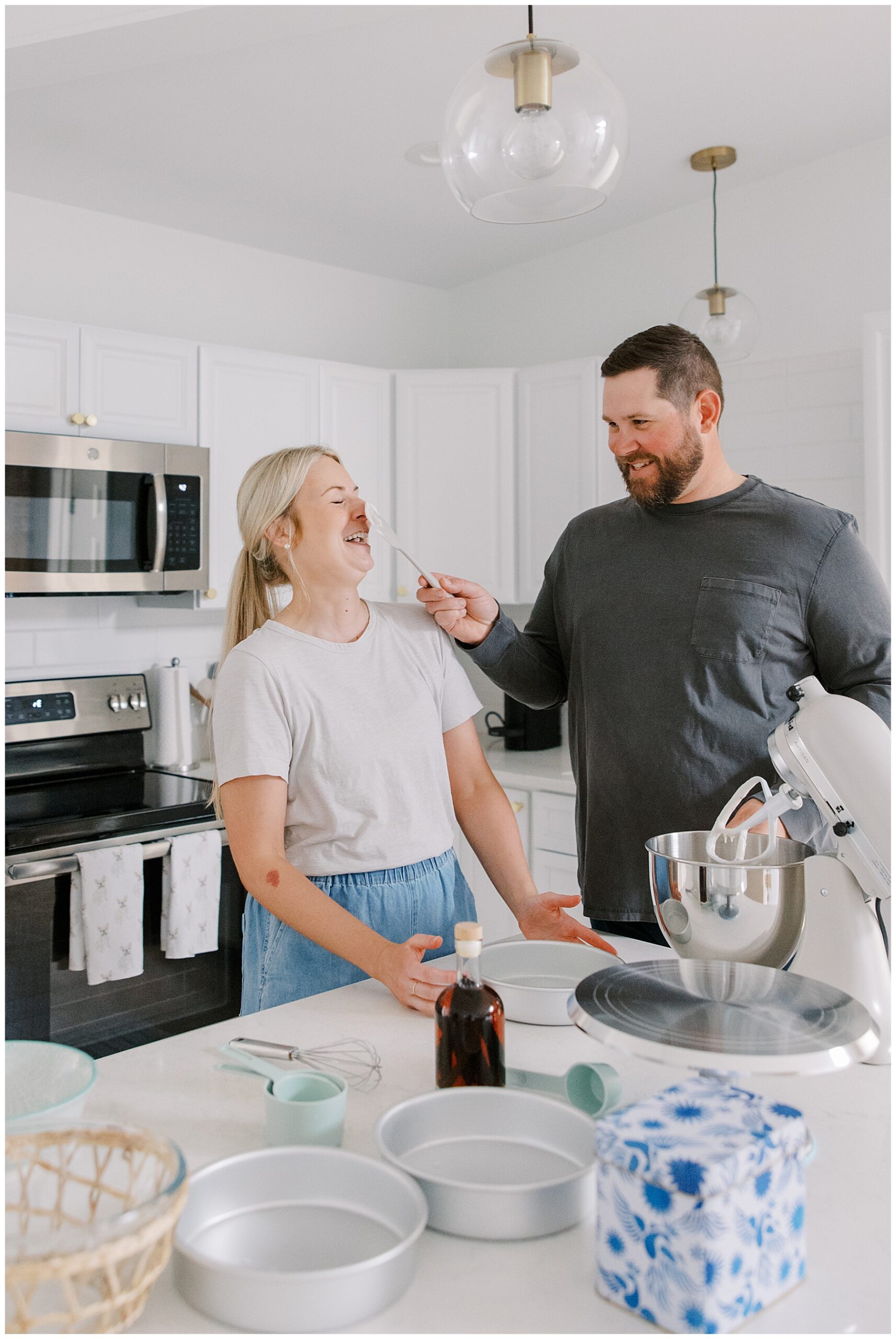 guy smears batter on fiance's nose during playful and Candid At-Home Engagement session