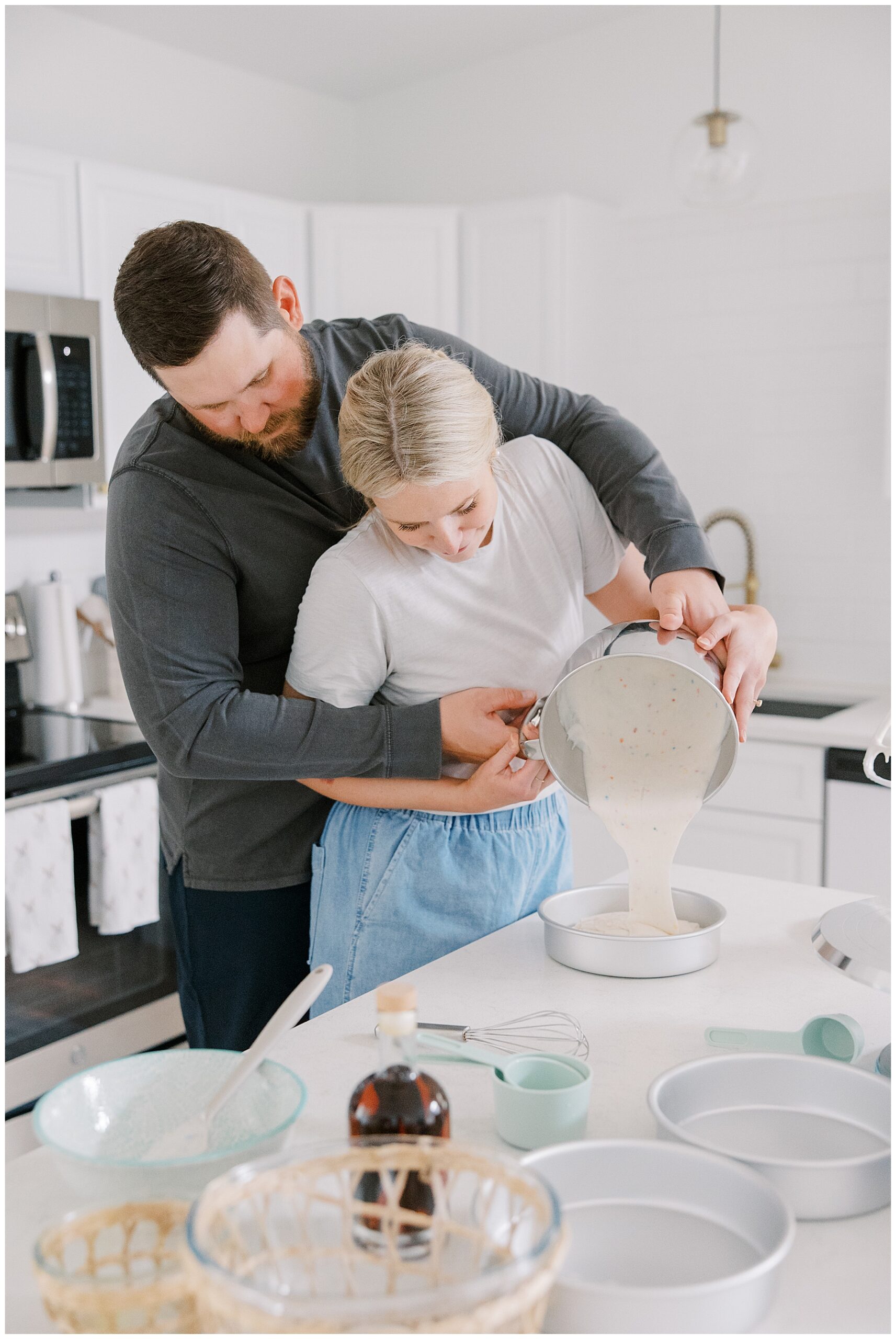 couple working together to pour cake batter in pans
