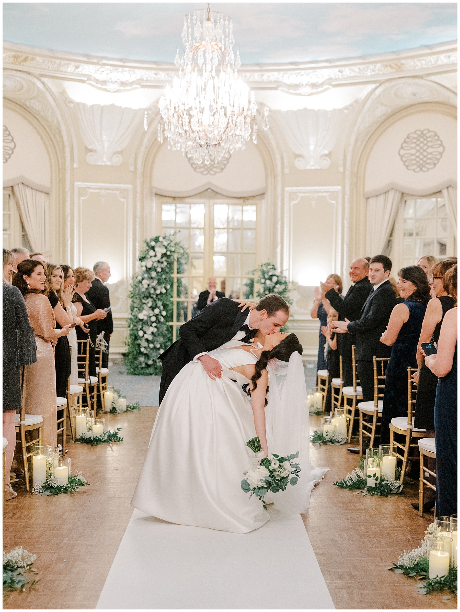 groom kisses his bride in the aisle