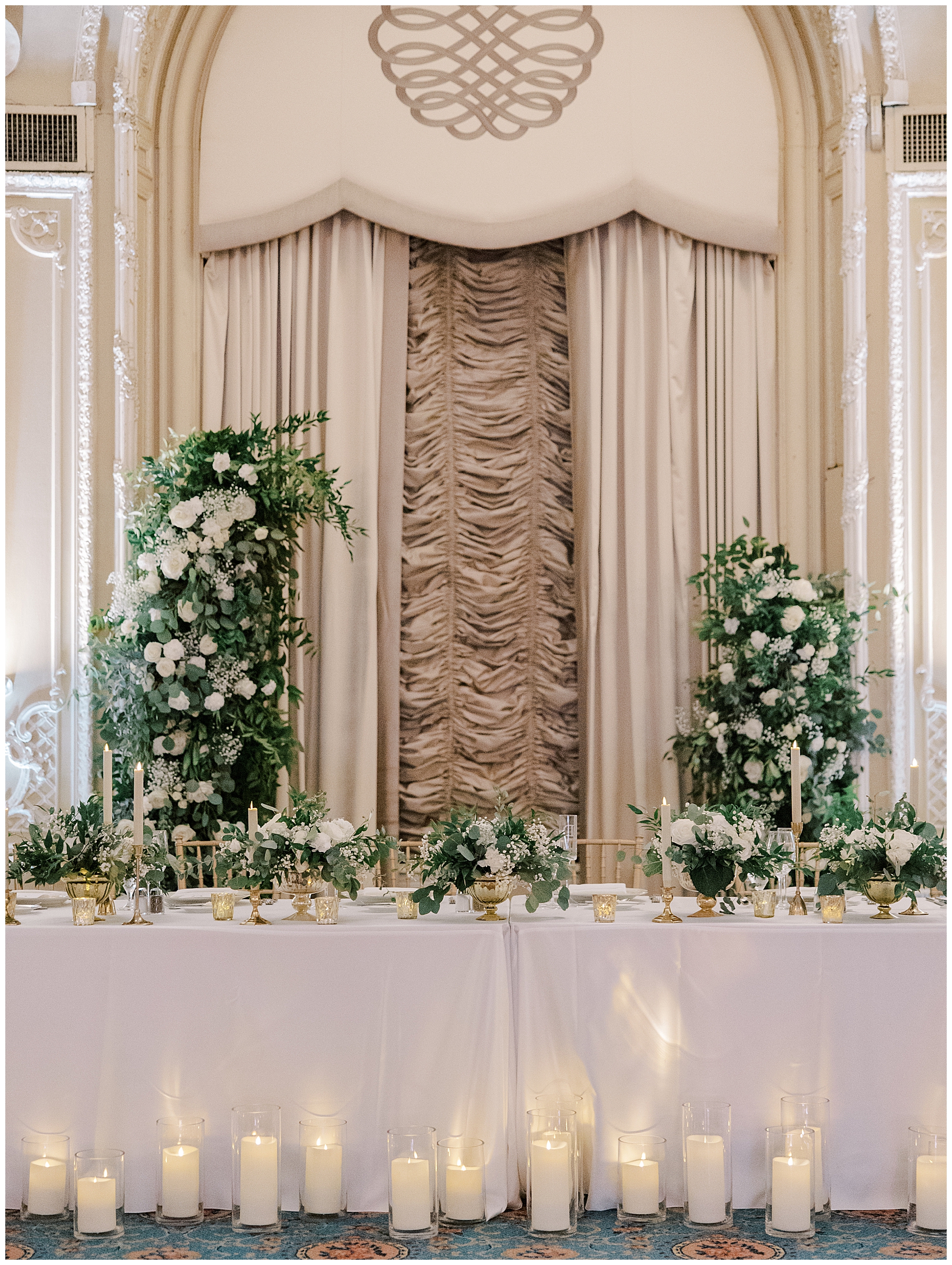 wedding head table decorated with floral display and flickering candles