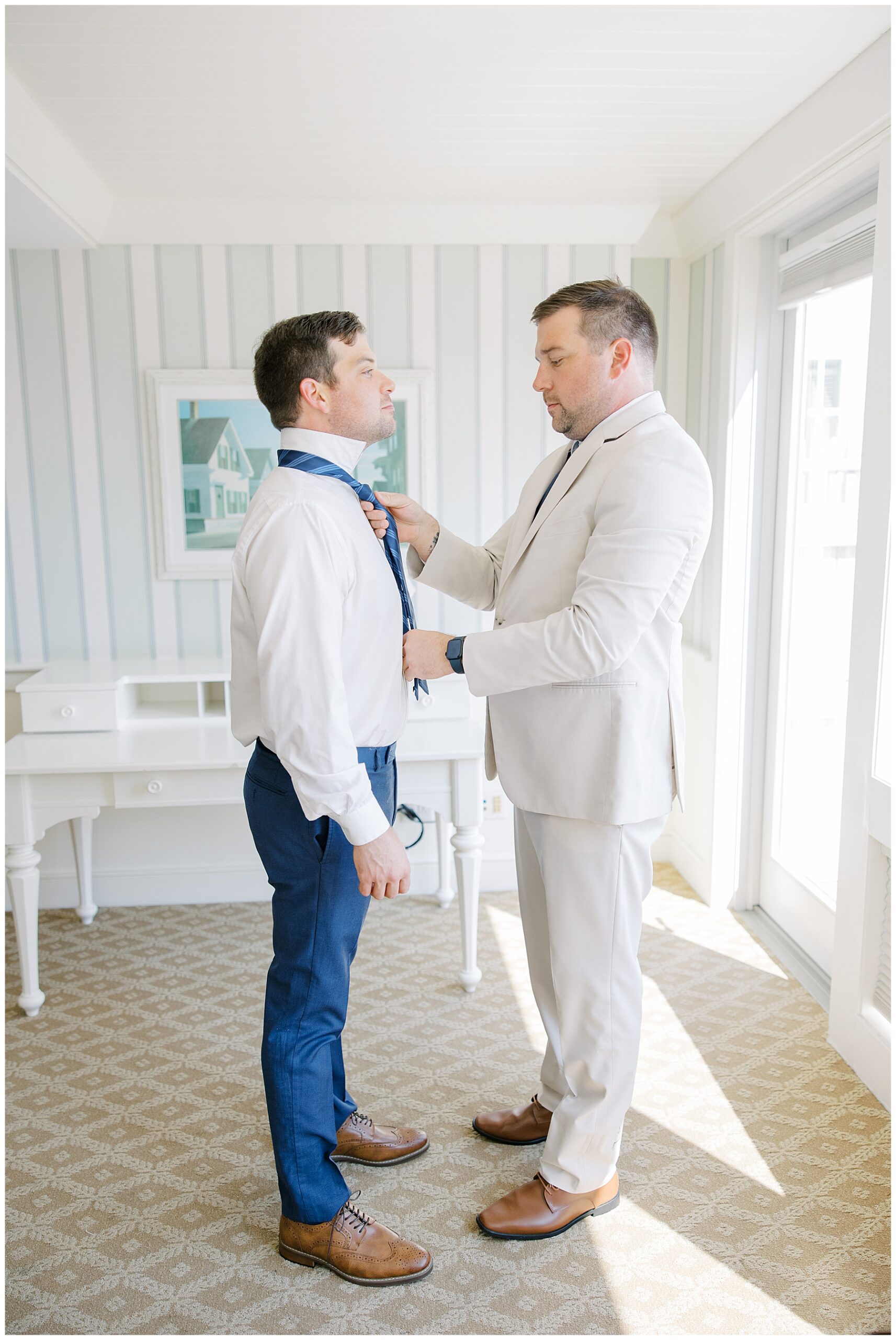 groom getting tie on with help from groomsmen