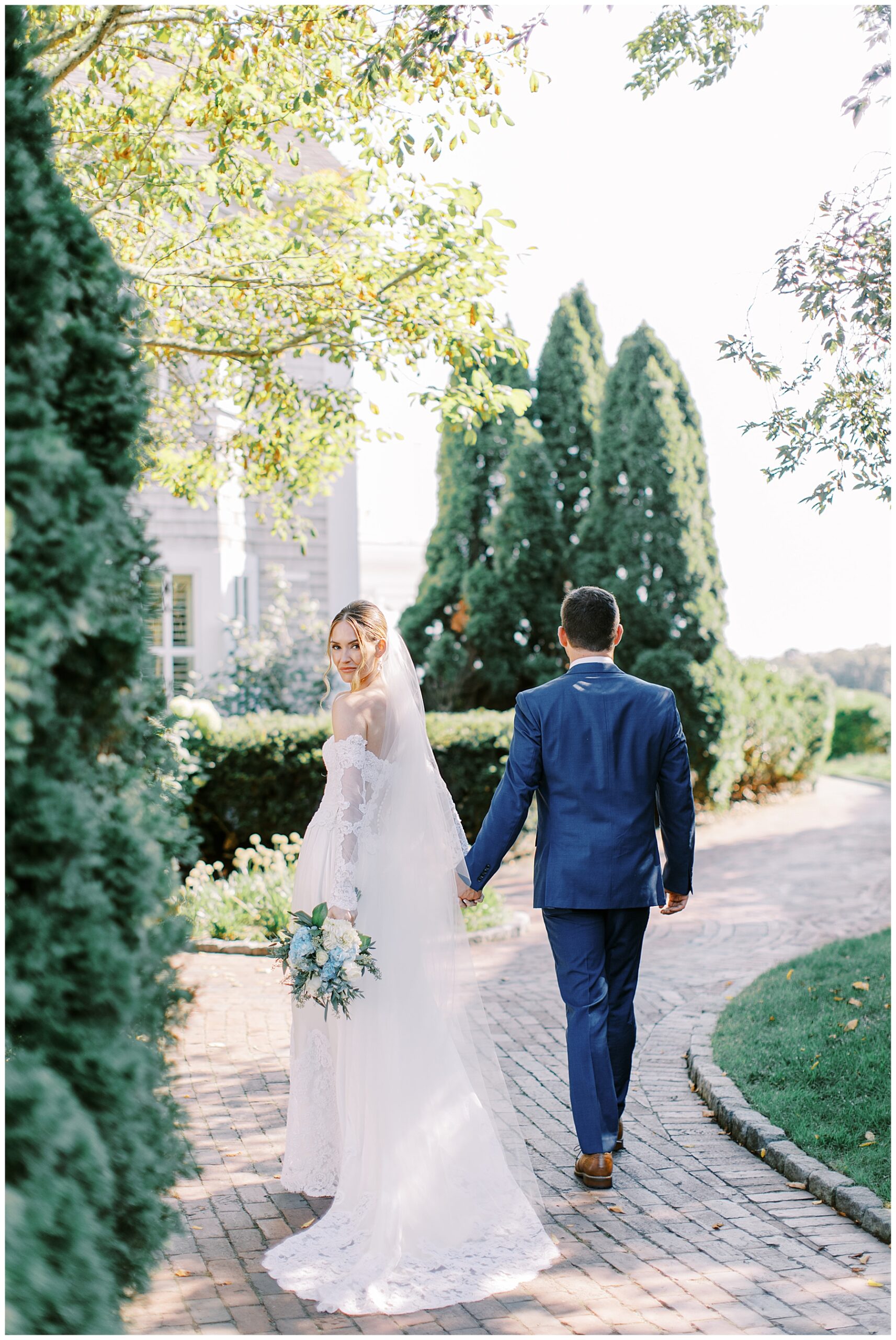 bride and groom hold hands as they walk together