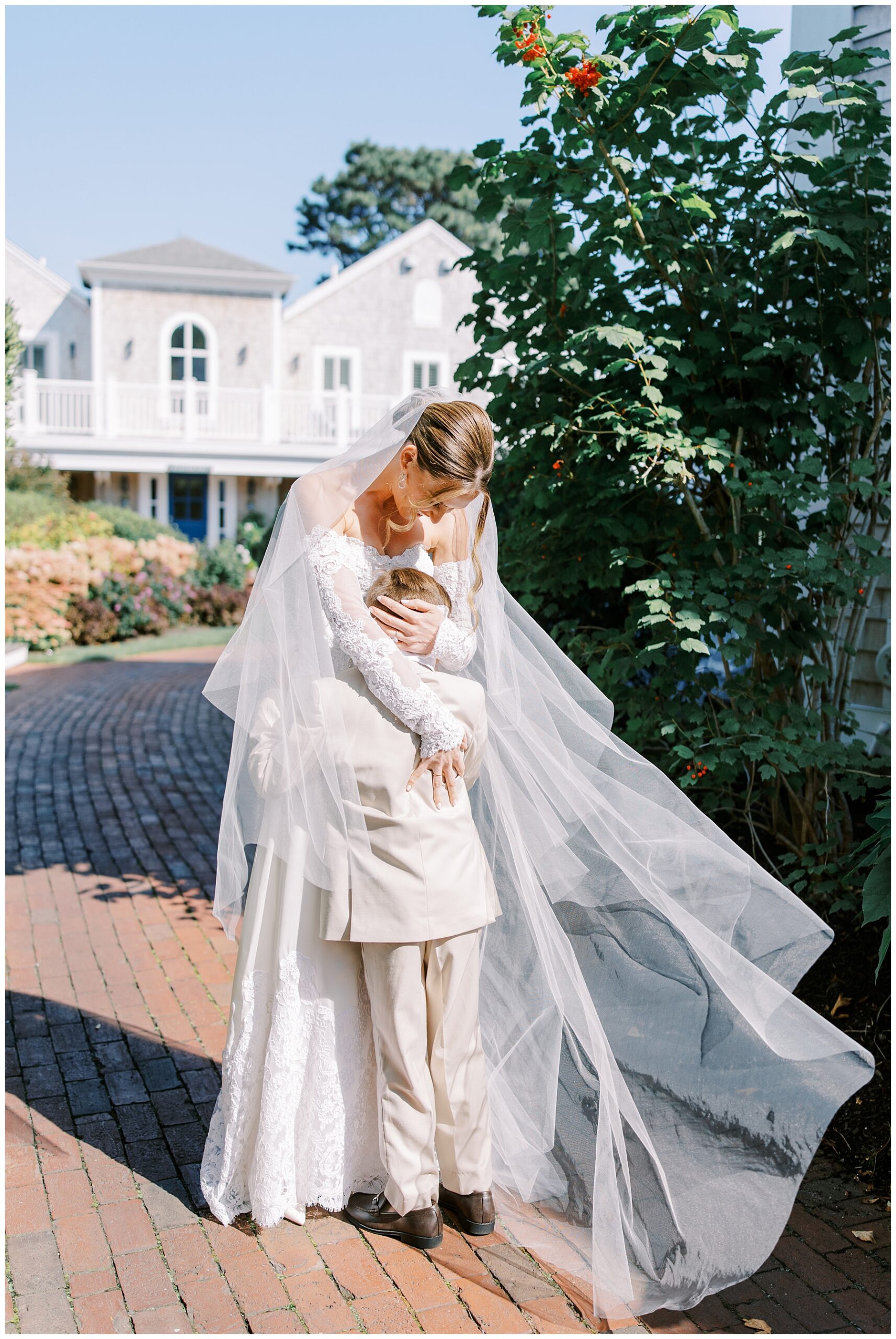 bride hugs her son as veil wraps around them