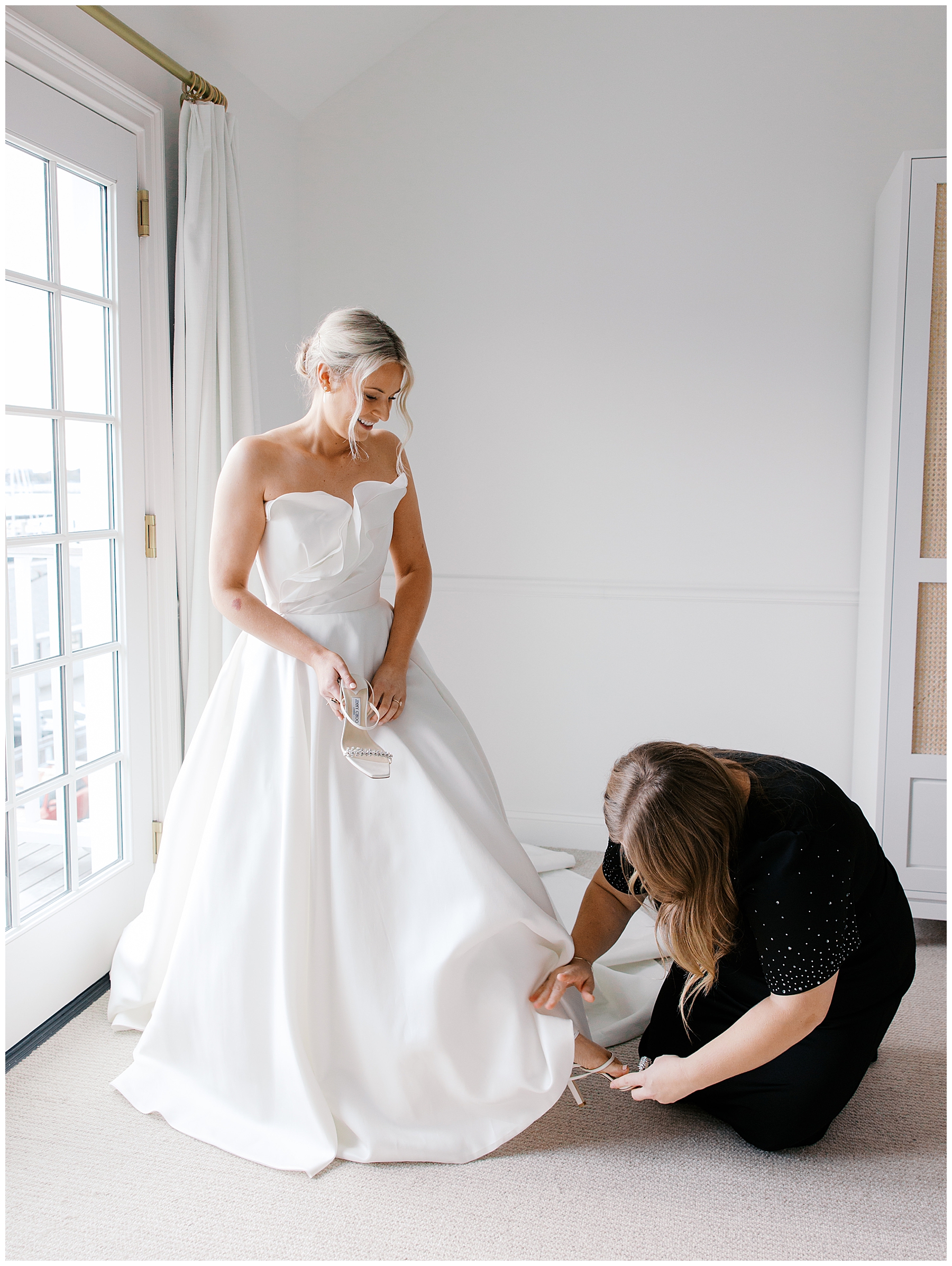 bride getting wedding shoes on with help
