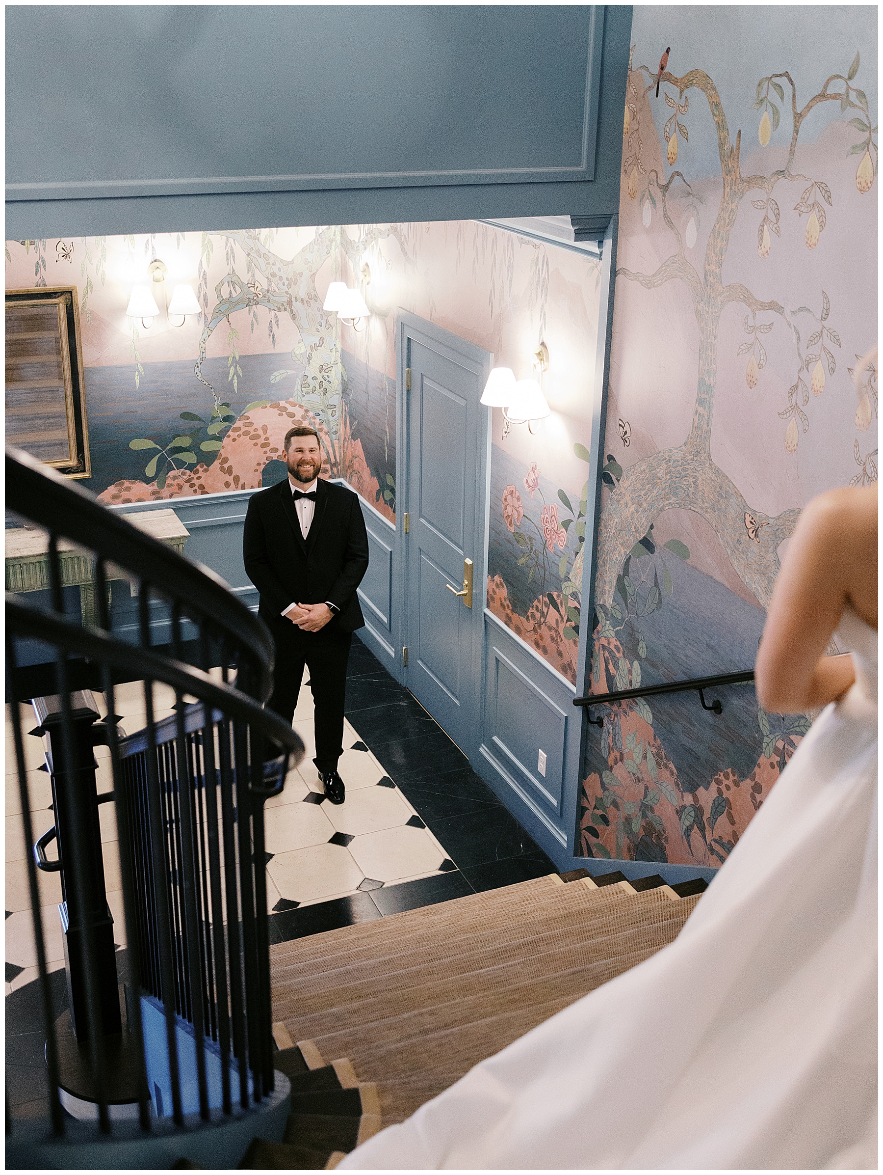groom sees bride for the first time at the top of staircase