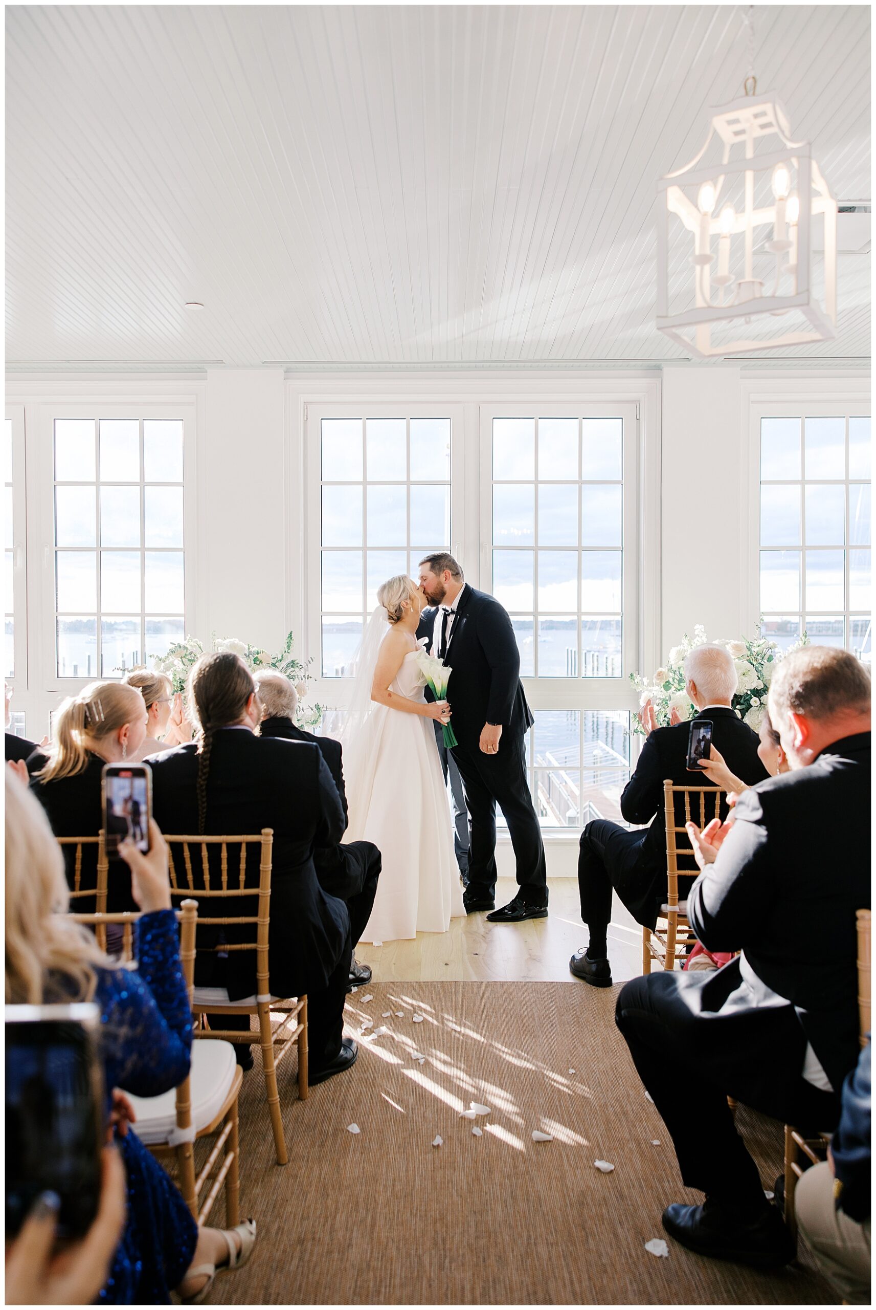 Newlyweds kiss at wedding ceremony in the Sun Room of Gardiner House wedding venue