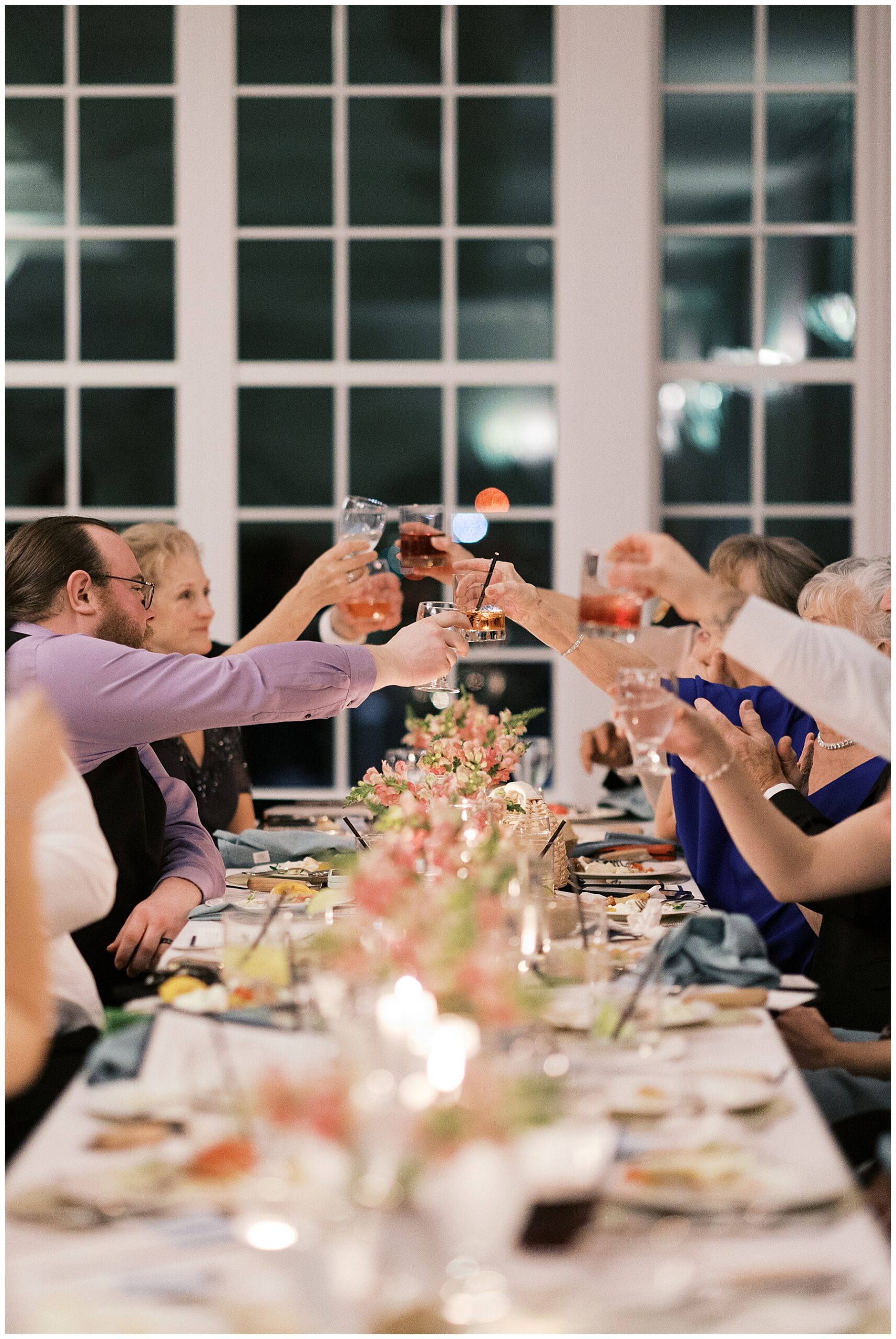 wedding guests raise their glasses in a toast