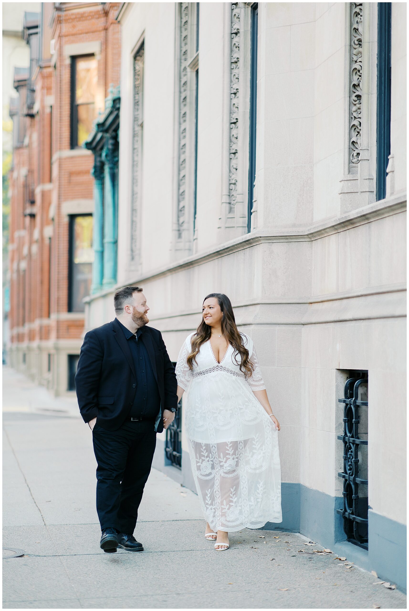 couple walk down sidewalk in downtown Boston