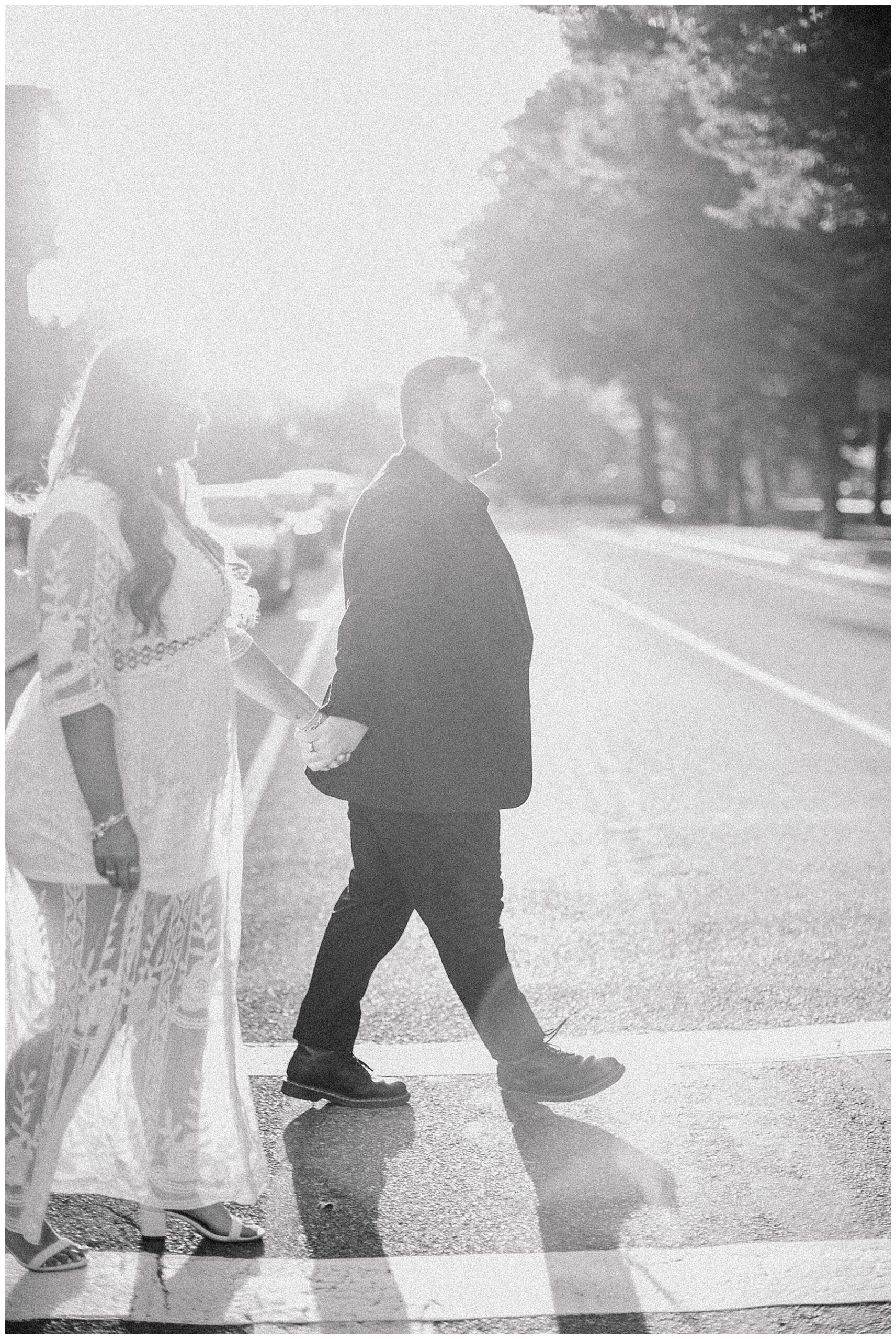 couple hold hands as they cross the street